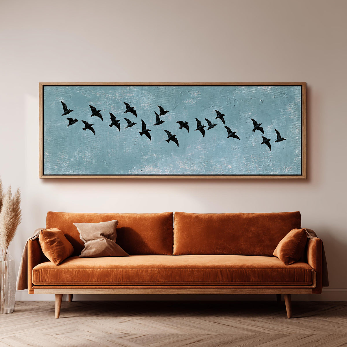 Flock of black birds on a teal sky panoramic canvas print above a sofa in a living room