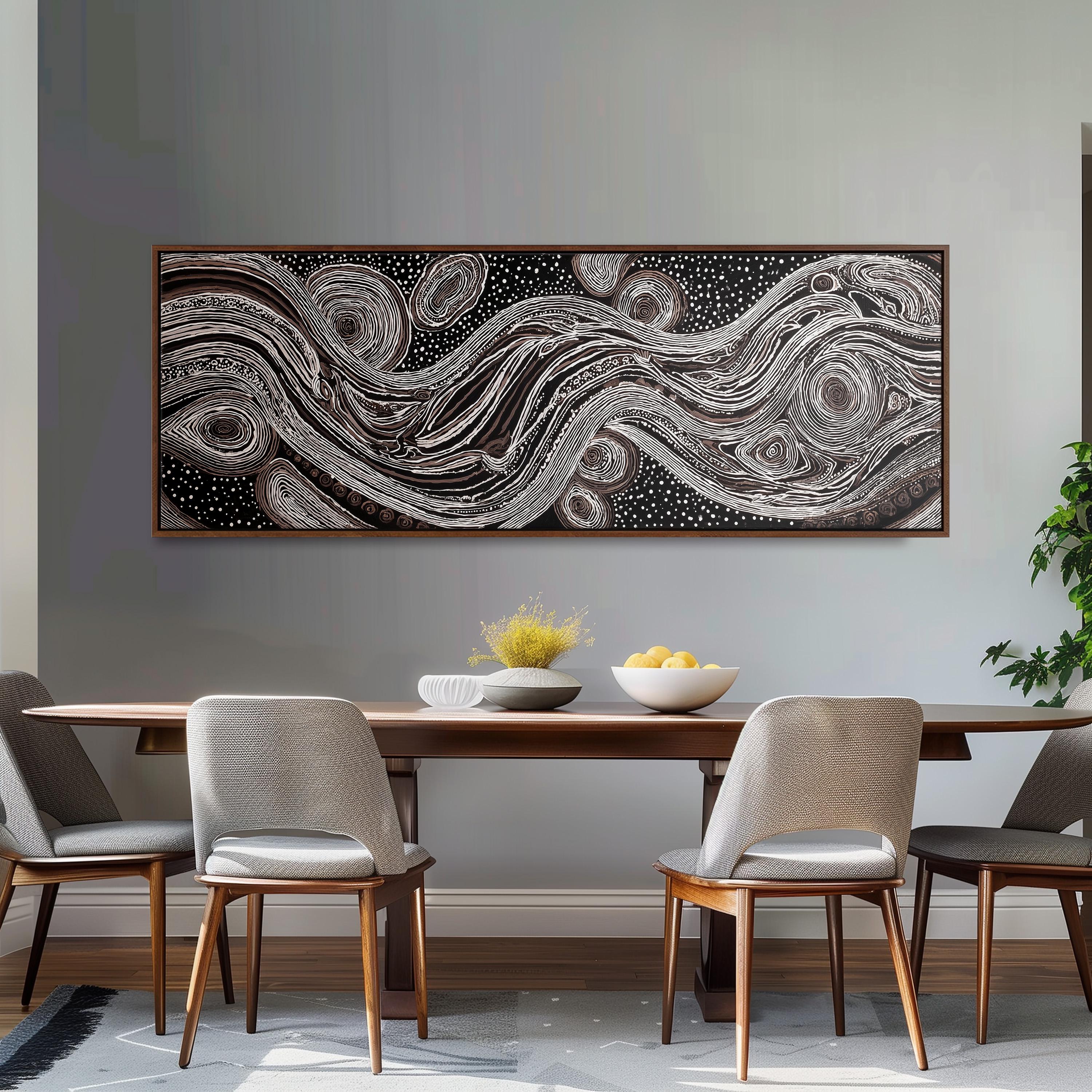 a dining room with a large abstract painting hanging on the wall above a wooden dining table with four chairs. The table is set with a bowl of fruit and a vase of flowers, creating a cozy and inviting atmosphere.