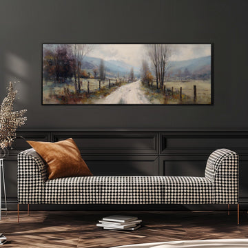a large painting of a rural road with trees and a fence, hanging on a wall above a black and white checkered sofa.
