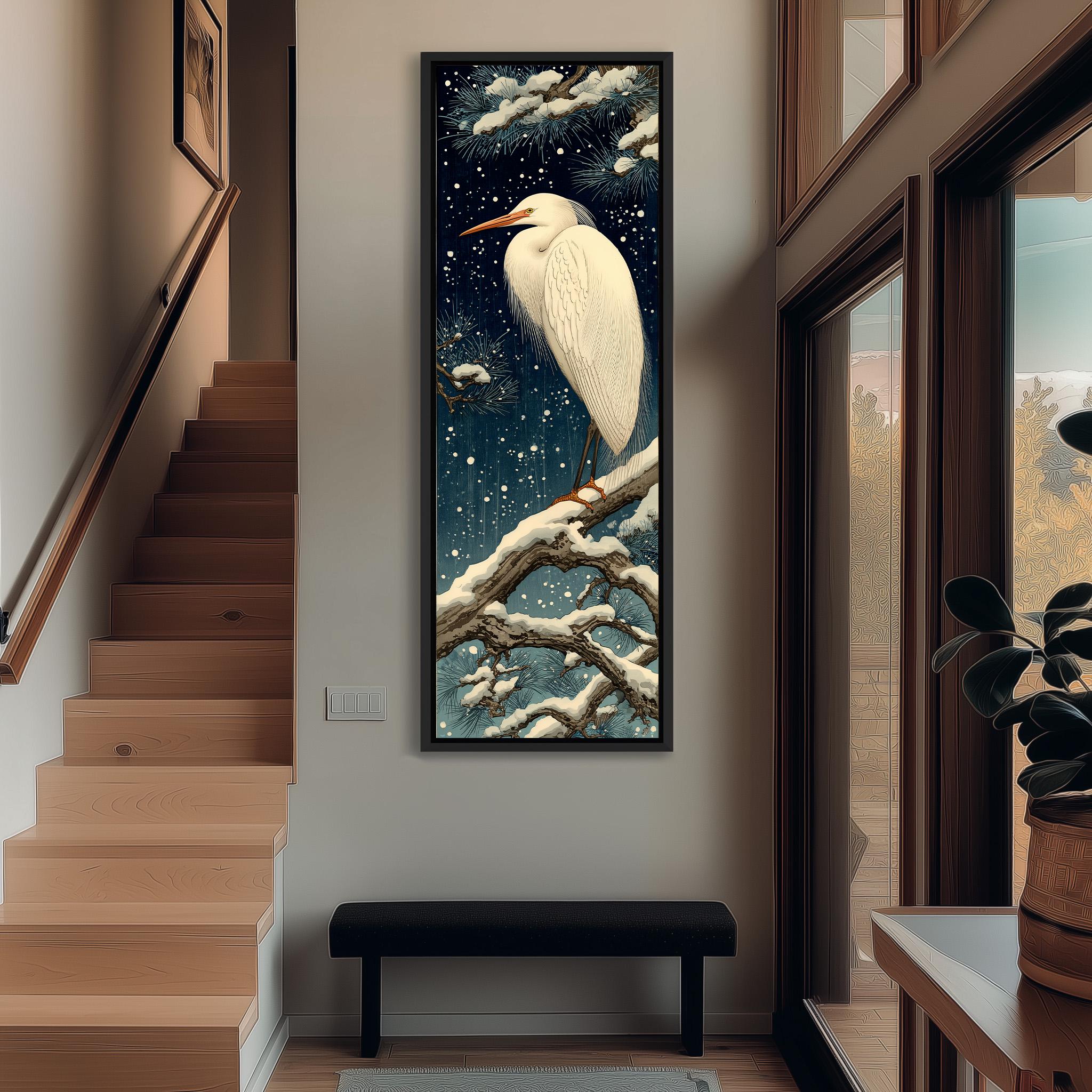 a large, framed painting of a white heron perched on a branch, set against a snowy night sky. The painting is hanging on a wall in a hallway, with a staircase visible in the background.