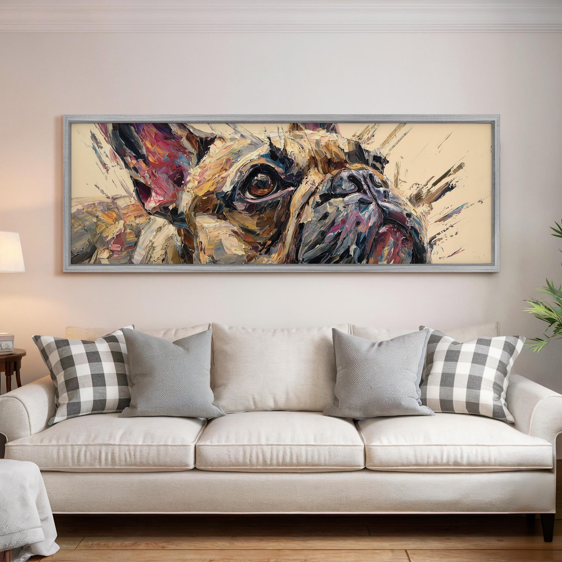 a large, colorful painting of a dog's face hanging on a wall above a white couch with gray and white plaid throw pillows.