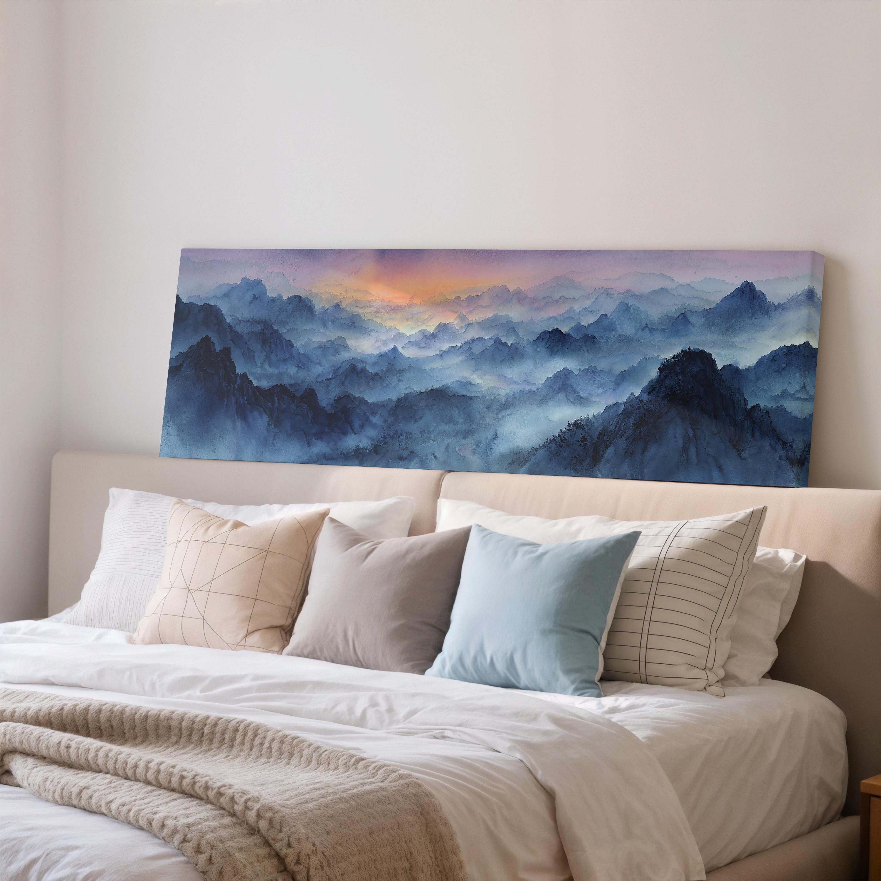 a large, framed painting of a mountainous landscape hanging on a wall above a bed with white bedding and pillows.