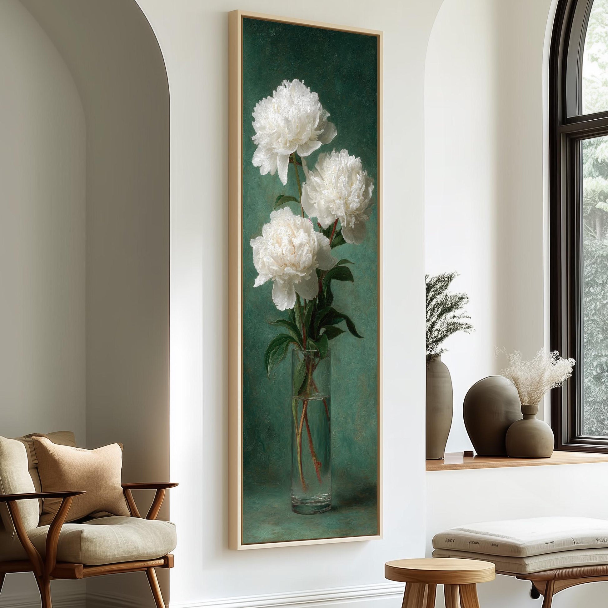 a large painting of white peonies hanging on a wall, with a vase containing white flowers placed in front of it. The painting is framed in a wooden frame, and there are two chairs and a small table in the room.
