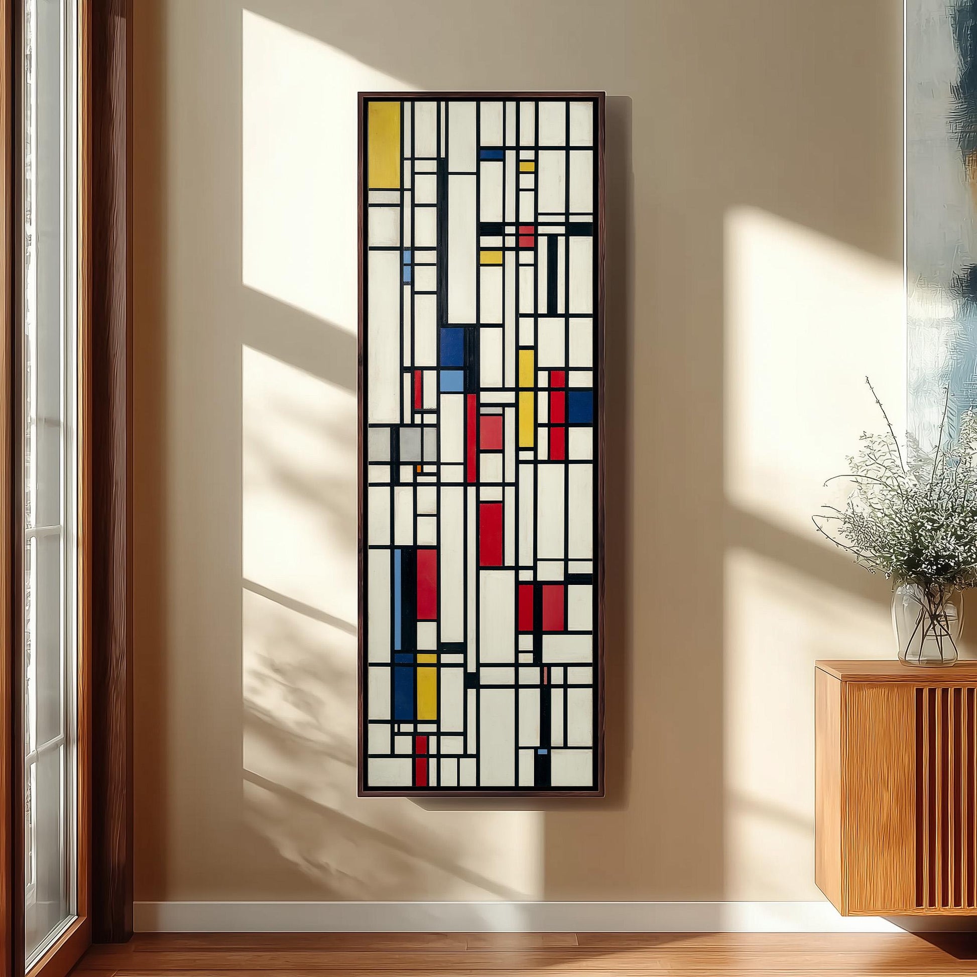 a large abstract painting hanging on a wall, with a wooden cabinet and a vase of flowers to the right of the painting.