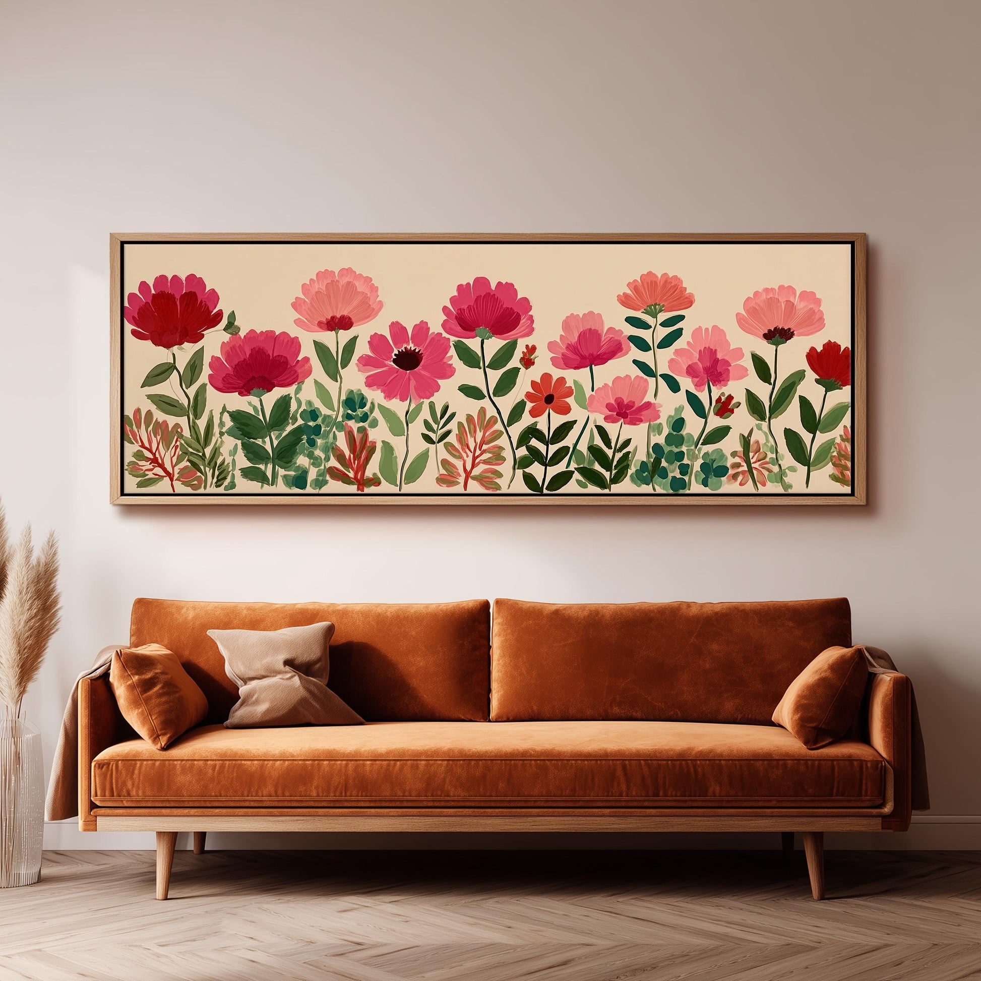 a large, framed print of a floral design hanging on a wall above a brown sofa.