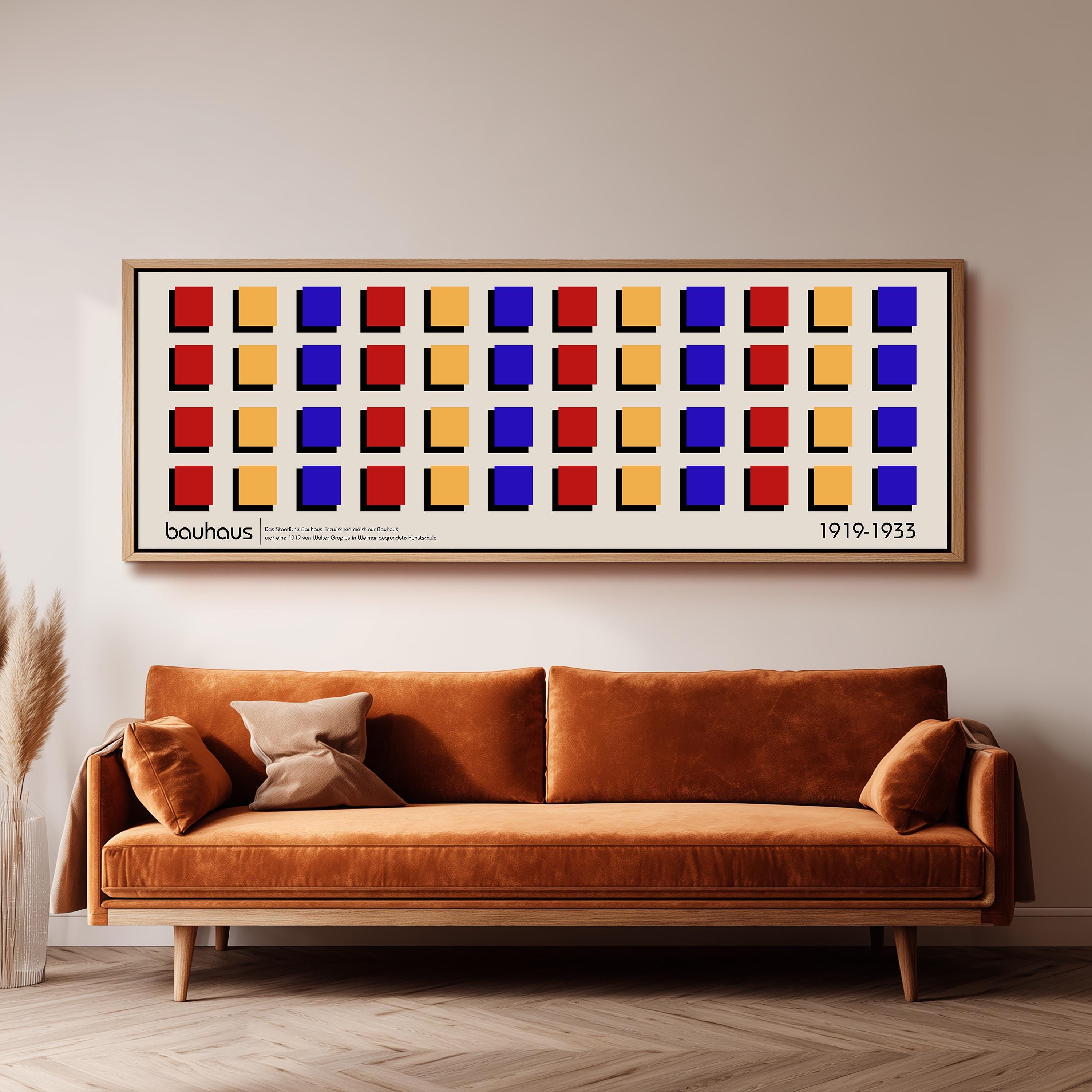 a large, rectangular framed poster with a repeating pattern of squares in various colors, including red, yellow, blue, and orange, hanging on a wall above a brown sofa.