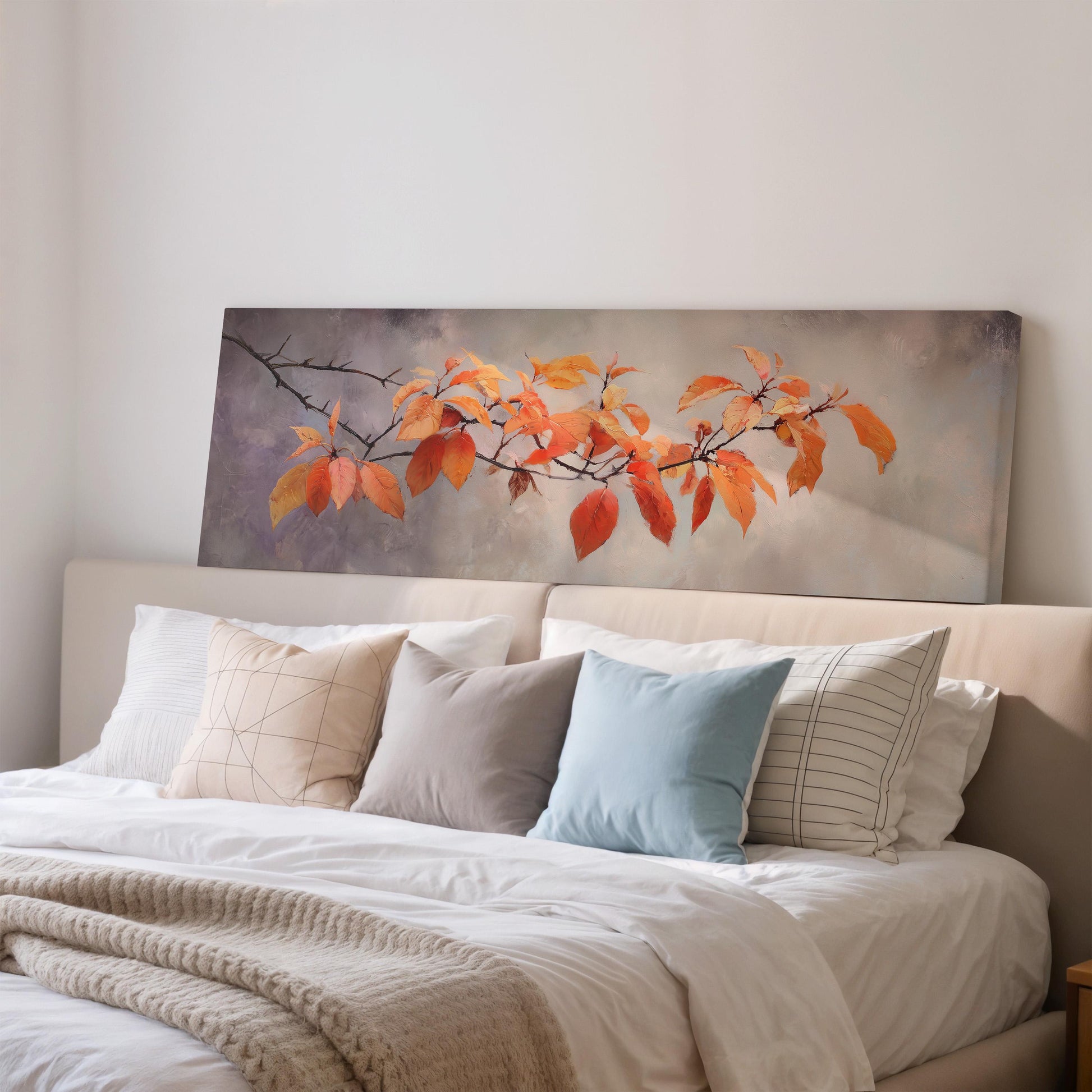 a large bed with a white comforter and pillows, and a painting of orange leaves hanging above it.