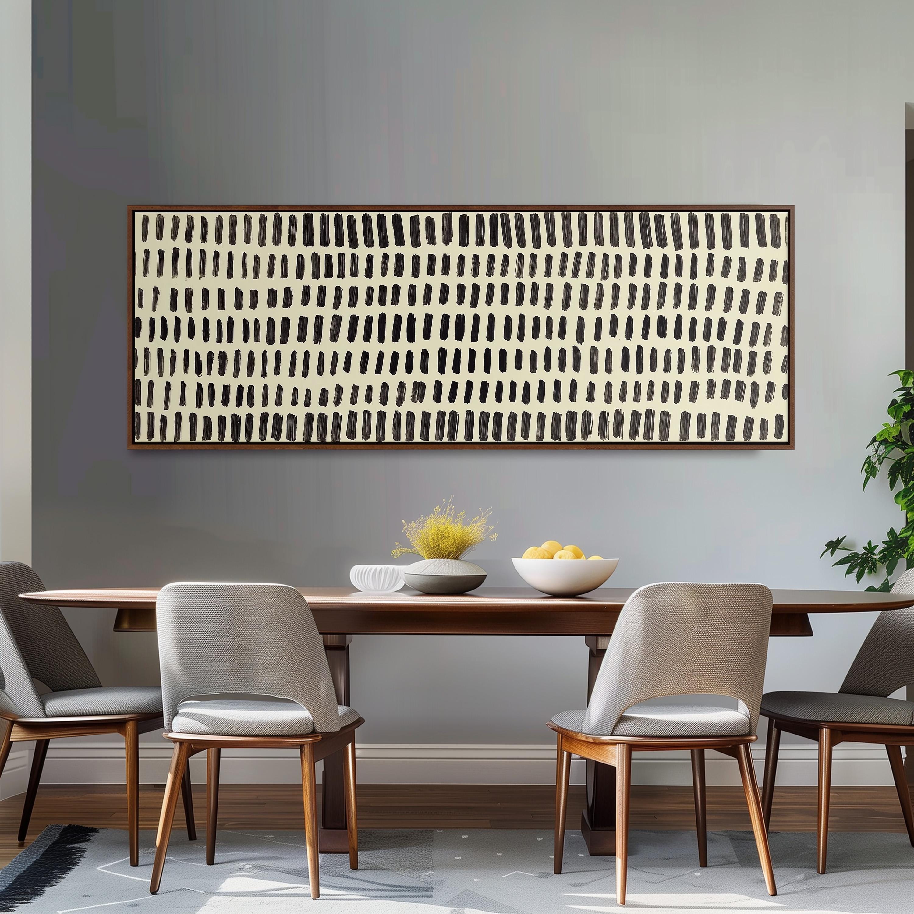 a modern dining room with a wooden table and four gray chairs. Above the table, there is a large abstract painting with a black and white striped pattern. On the table, there is a bowl of fruit and a vase of flowers.
