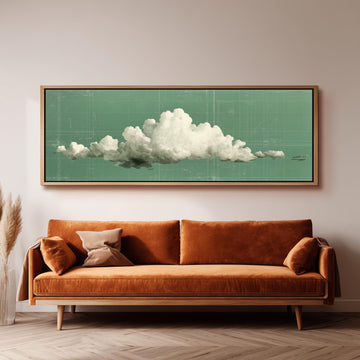 a large framed artwork depicting a cloud on a green background, hanging on a wall above a brown sofa with two pillows.