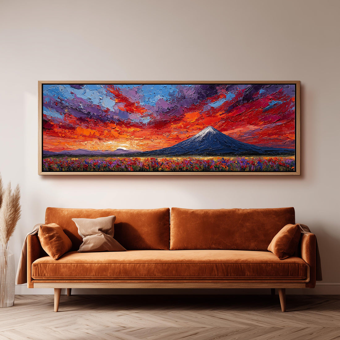 a large, vibrant painting of a mountain landscape hanging on a wall above a brown sofa.