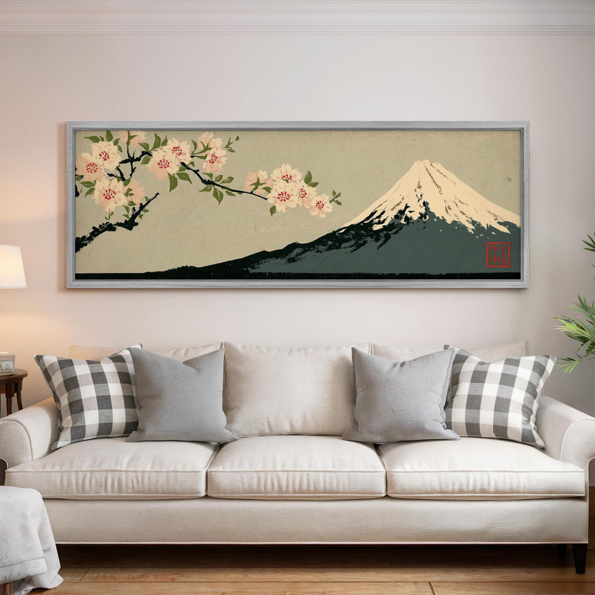 Cherry blossom branch and Mount Fuji panoramic canvas print above a white sofa in a bright living room