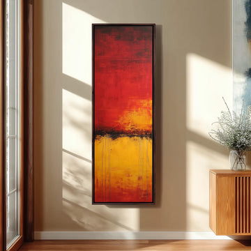 a large abstract painting hanging on a wall, with a wooden cabinet and a vase of flowers to the right of the painting.