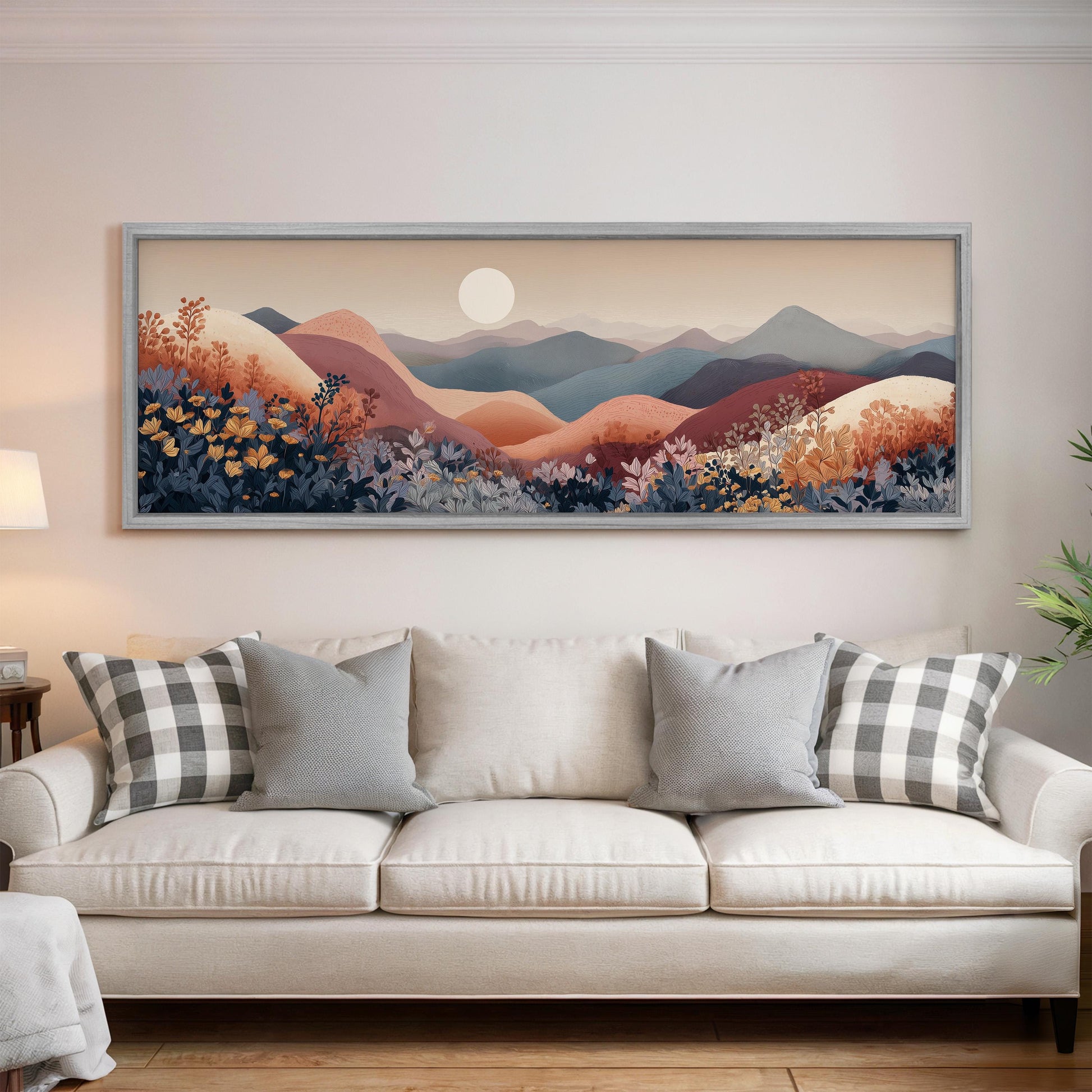 a large, framed landscape painting hanging on a wall above a white sofa with decorative pillows.