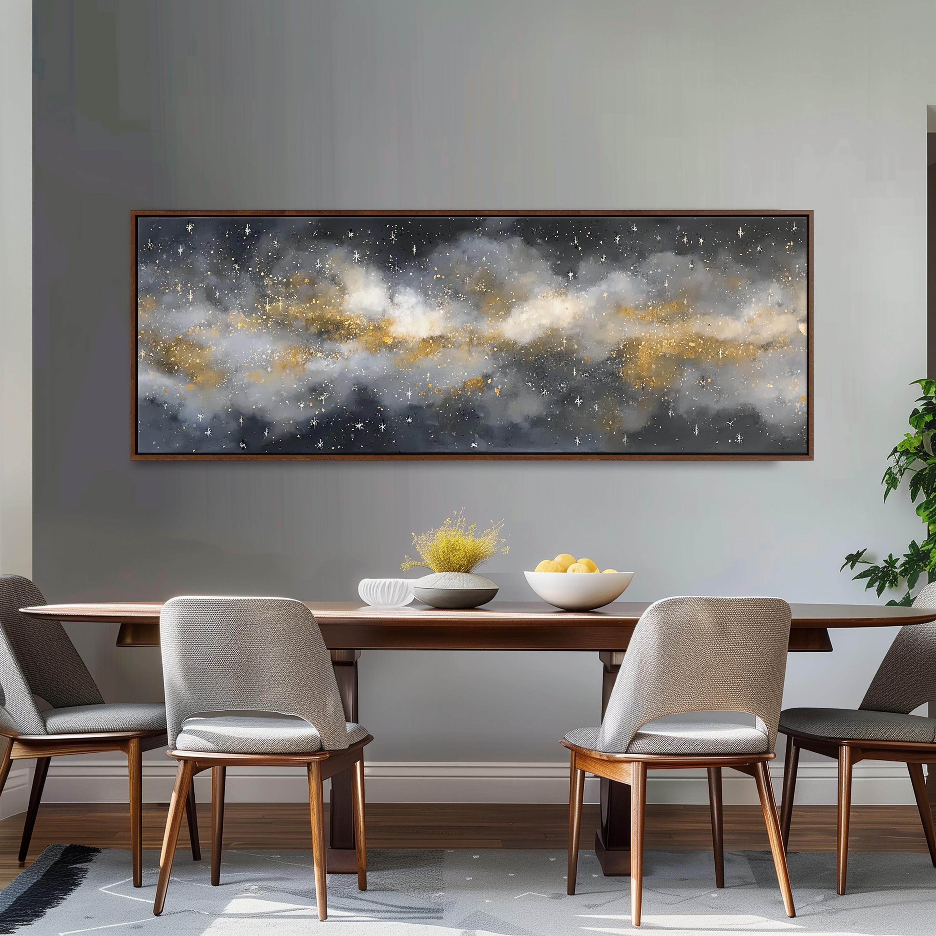 a dining room with a large, framed painting of a starry night sky hanging on the wall above a wooden dining table with four chairs. The table is set with a bowl of fruit and a vase of flowers, creating a cozy and inviting atmosphere.