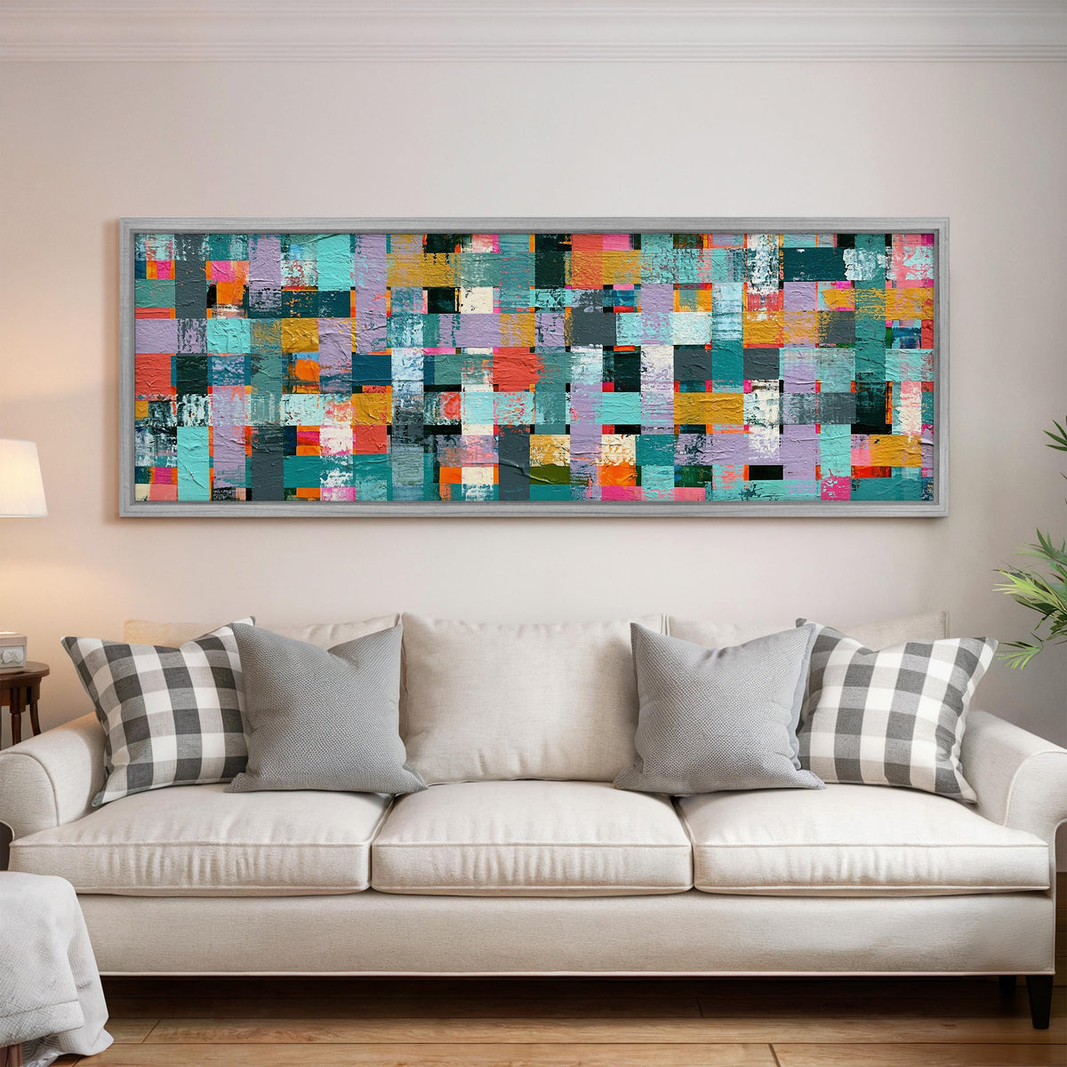 Woven grid of teal and pink blocks panoramic canvas print above a white sofa in a bright living room