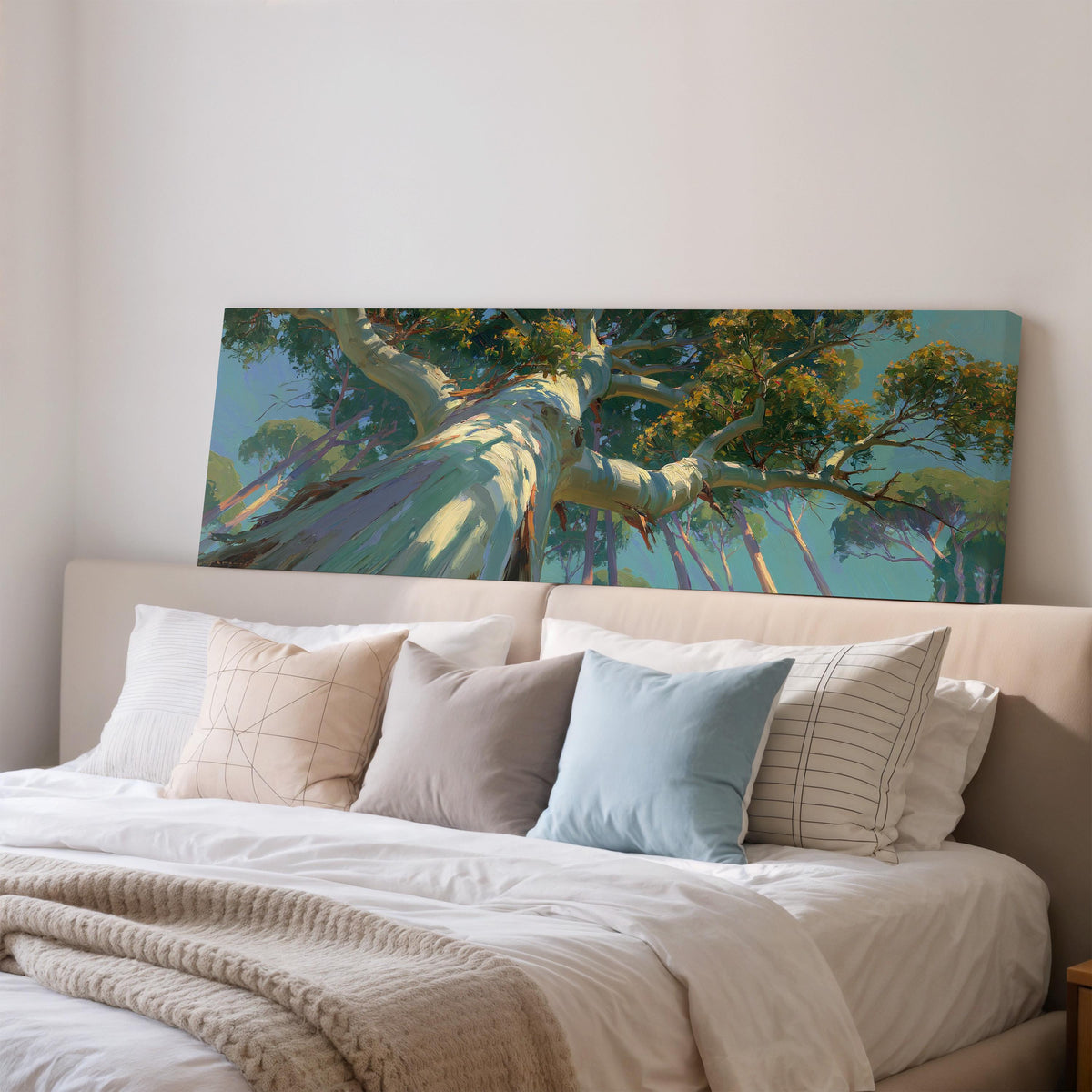 Eucalyptus canopy against a blue sky wide panoramic canvas print above a bed in a bedroom