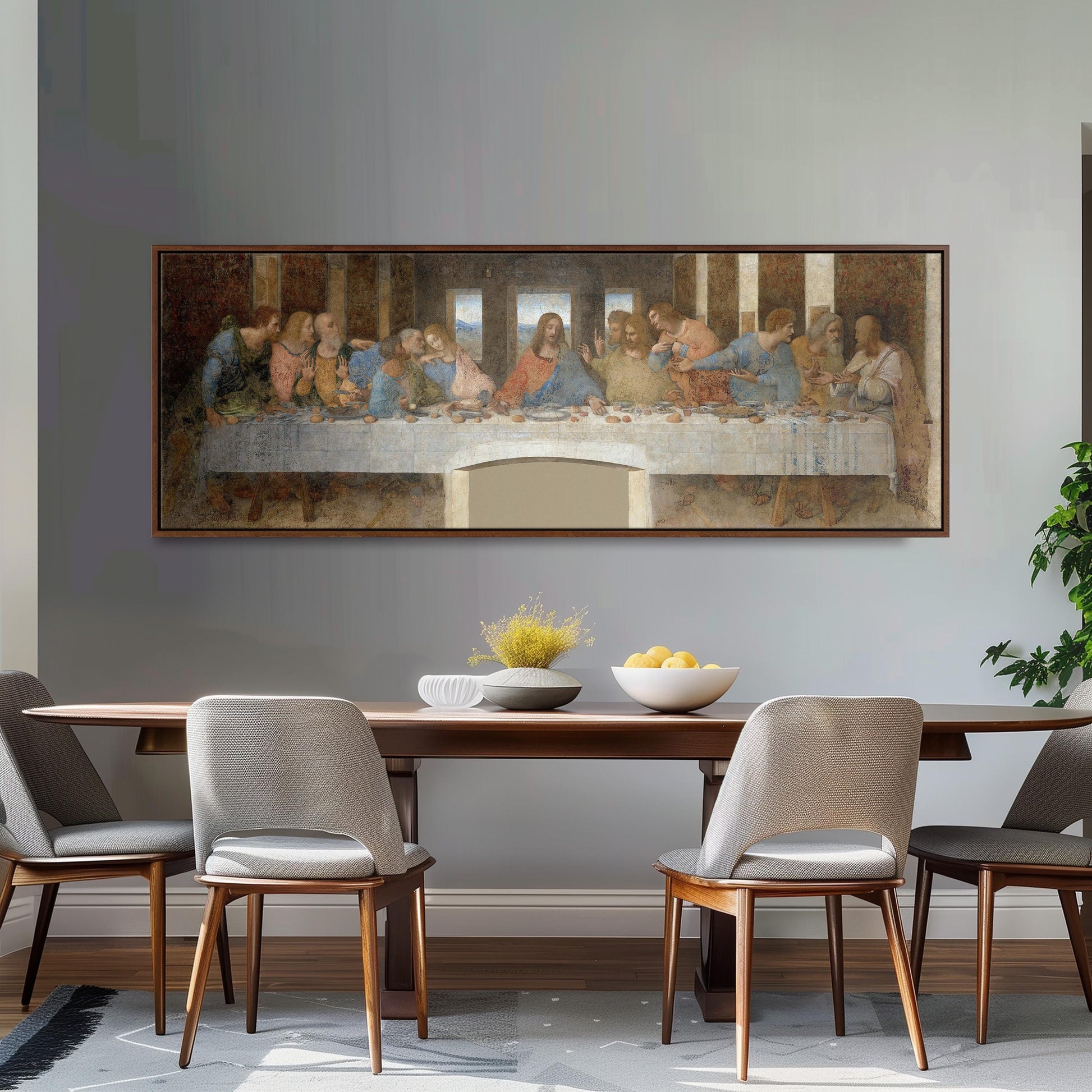 a large painting of the Last Supper hanging on a wall above a wooden dining table with four chairs.