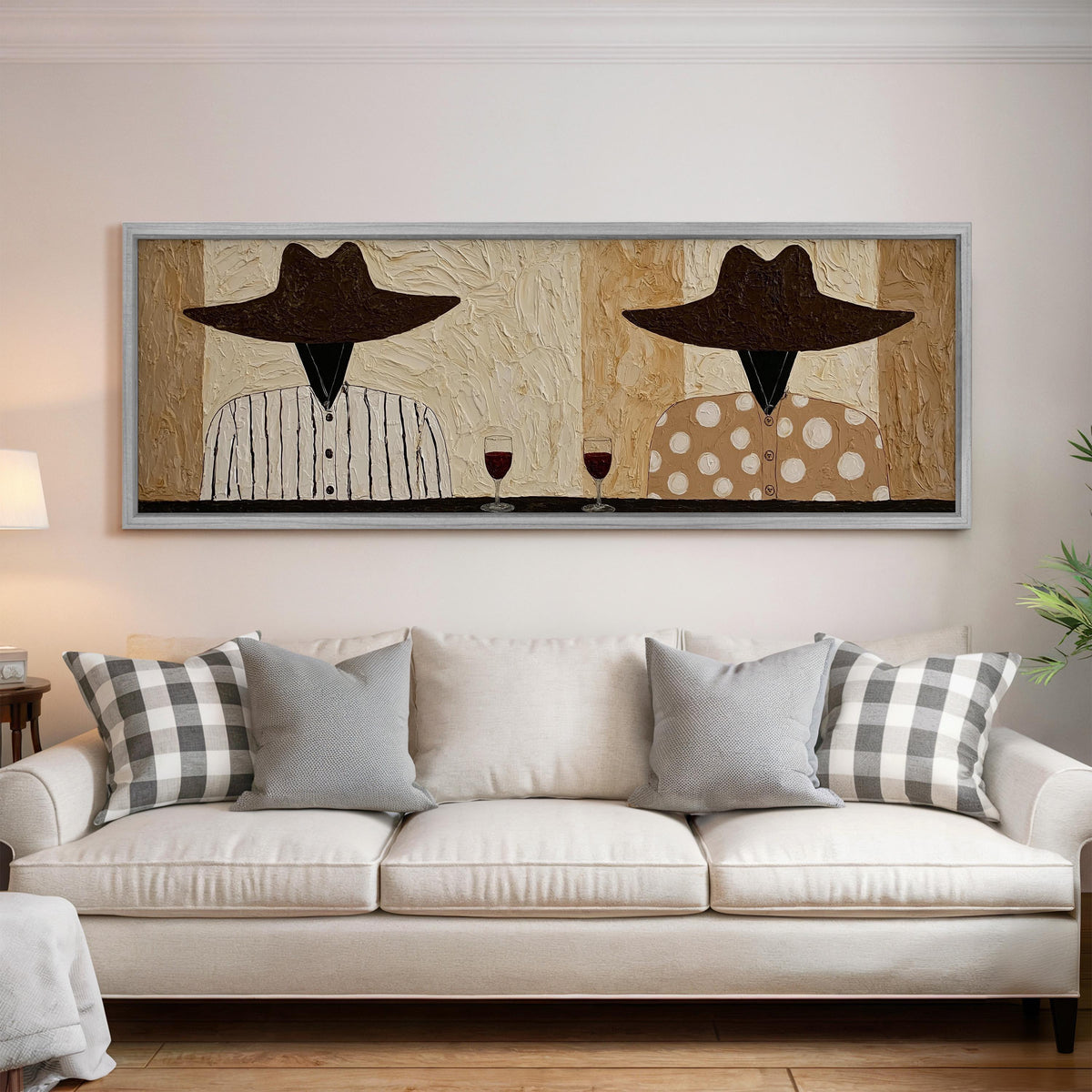 Two folk figures in hats toasting with red wine panoramic canvas print above a white sofa in a bright living room