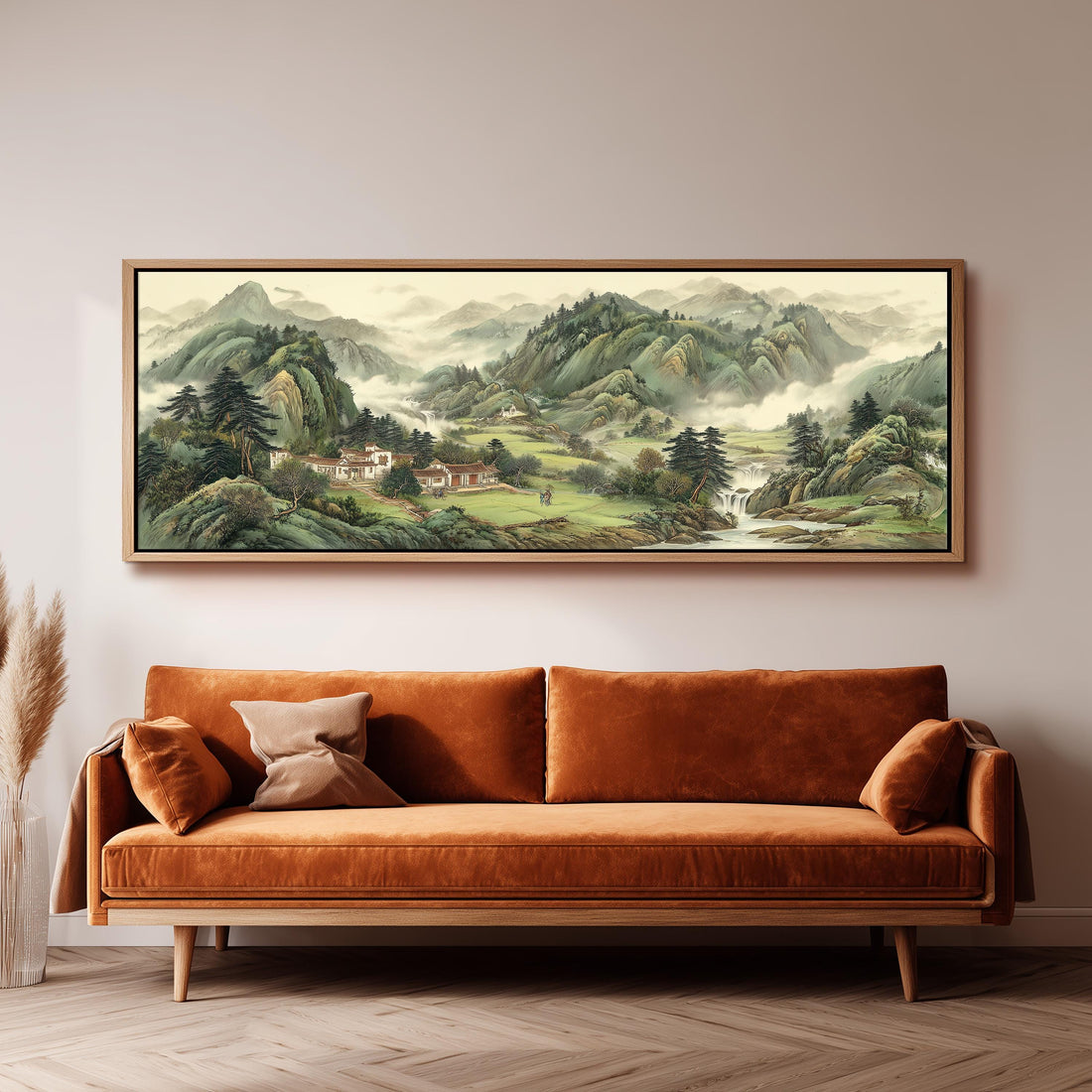 a large landscape painting hanging on a wall above a brown sofa with orange cushions.