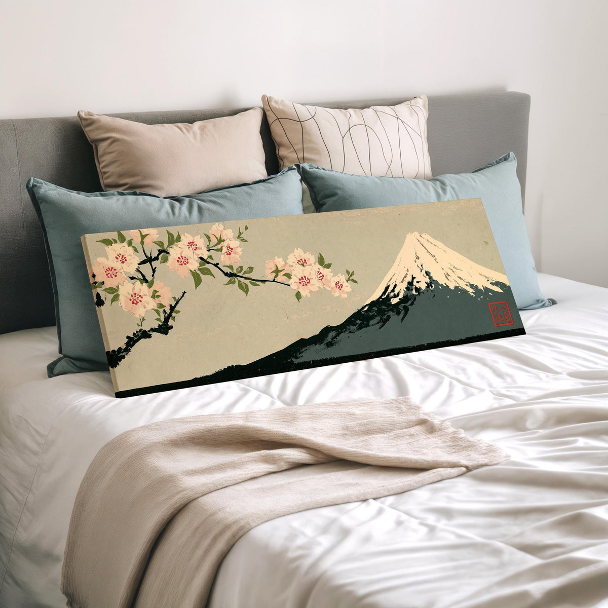 Cherry blossom branch and Mount Fuji wide panoramic canvas print laid on a bed to show its size