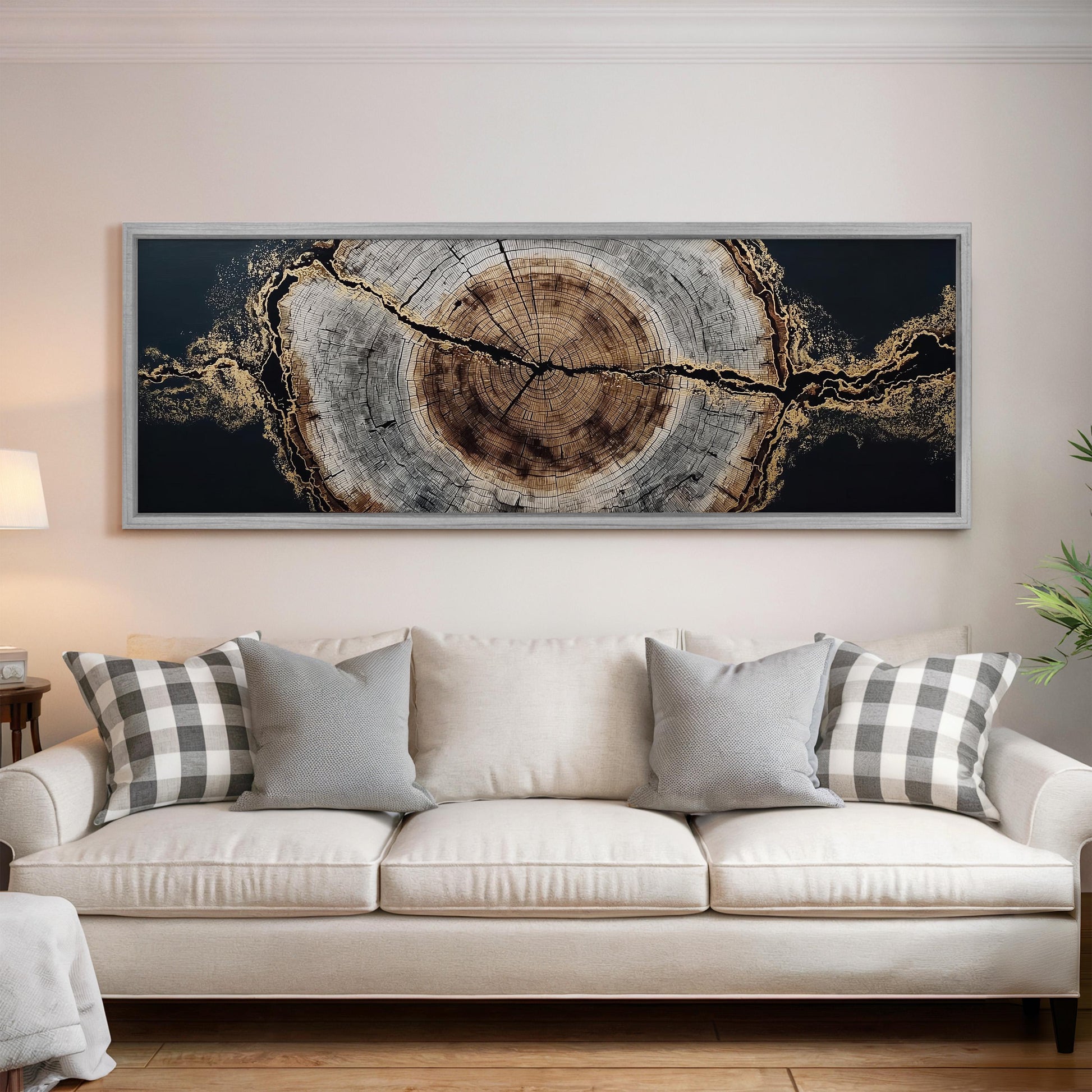 a large, framed artwork hanging on a wall above a white couch with gray and white plaid throw pillows.