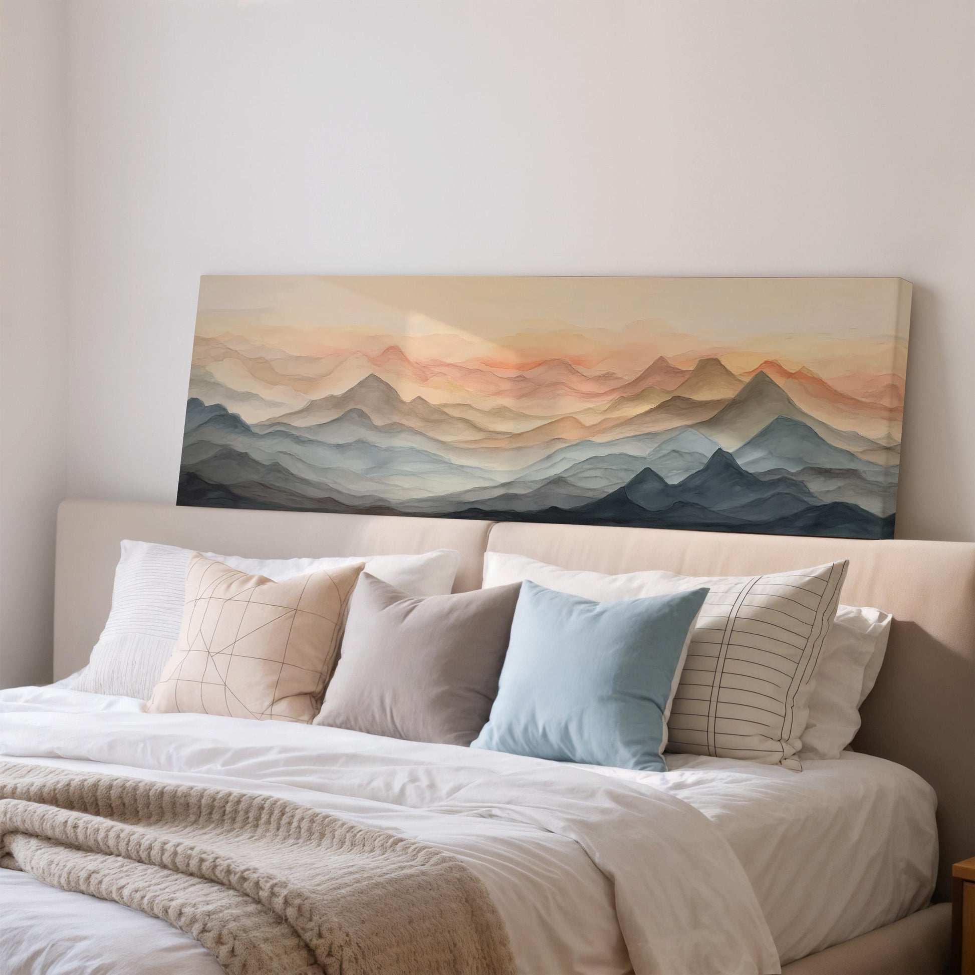 a large, white bed with a painting of mountains on the wall above it. The painting has a warm, sunset-like color palette, creating a serene and peaceful atmosphere in the bedroom.