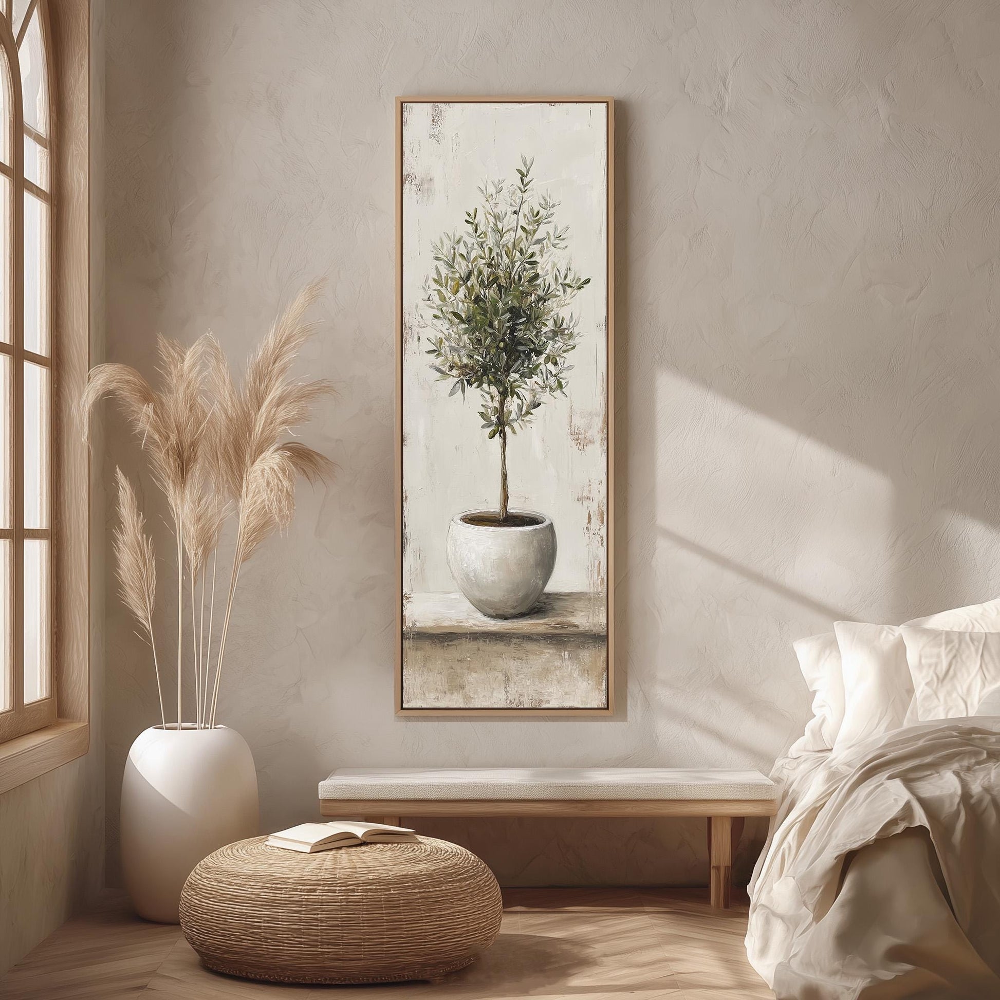 a serene and cozy bedroom scene, featuring a large painting of a potted olive tree hanging on the wall, a white vase with tall pampas grasses, a wooden bench, and a woven ottoman.