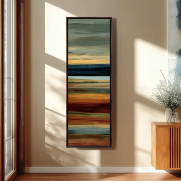 a large, colorful abstract painting hanging on a wall in a room with a wooden floor and a window.