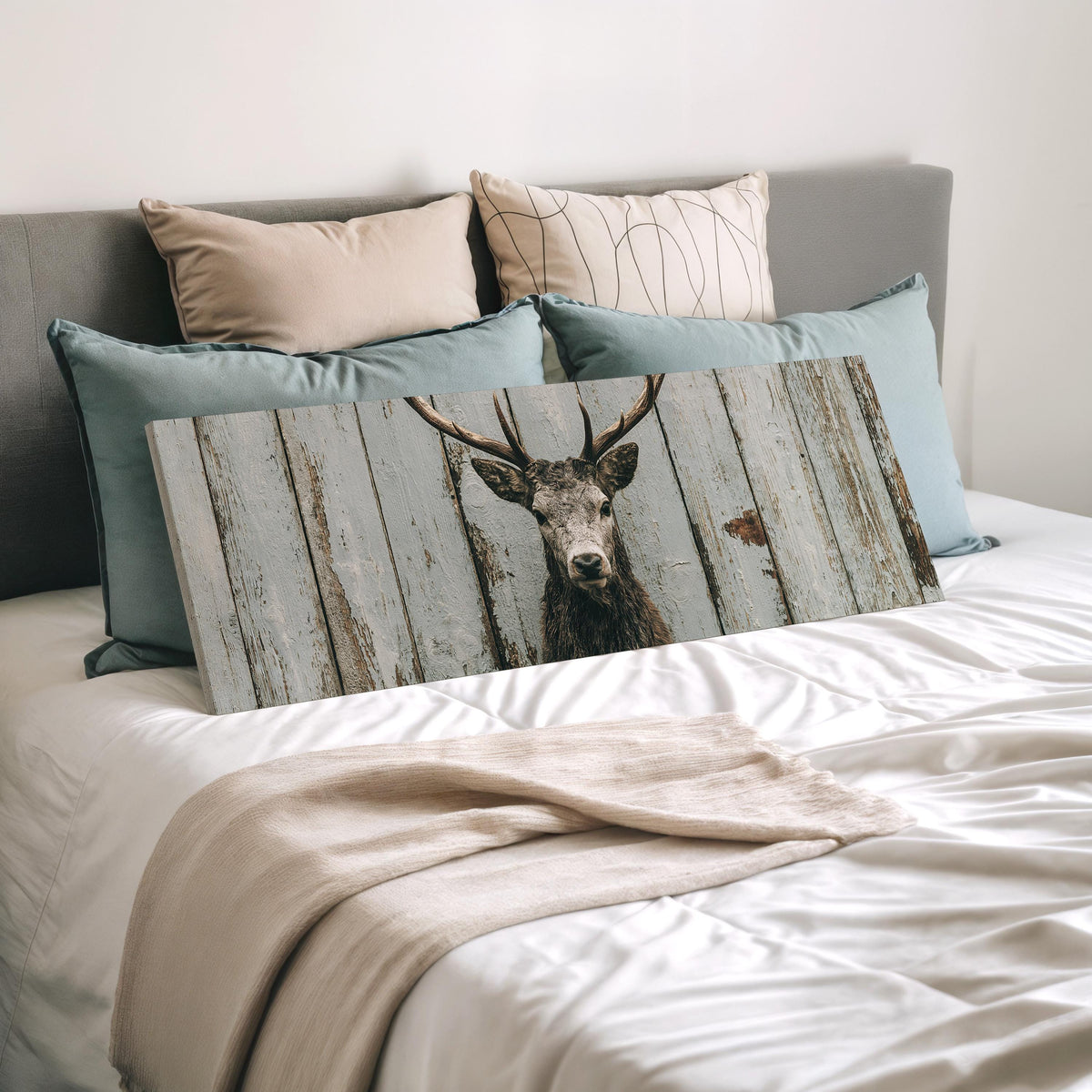 Monochrome stag on barn wood wide panoramic canvas print laid on a bed to show its size