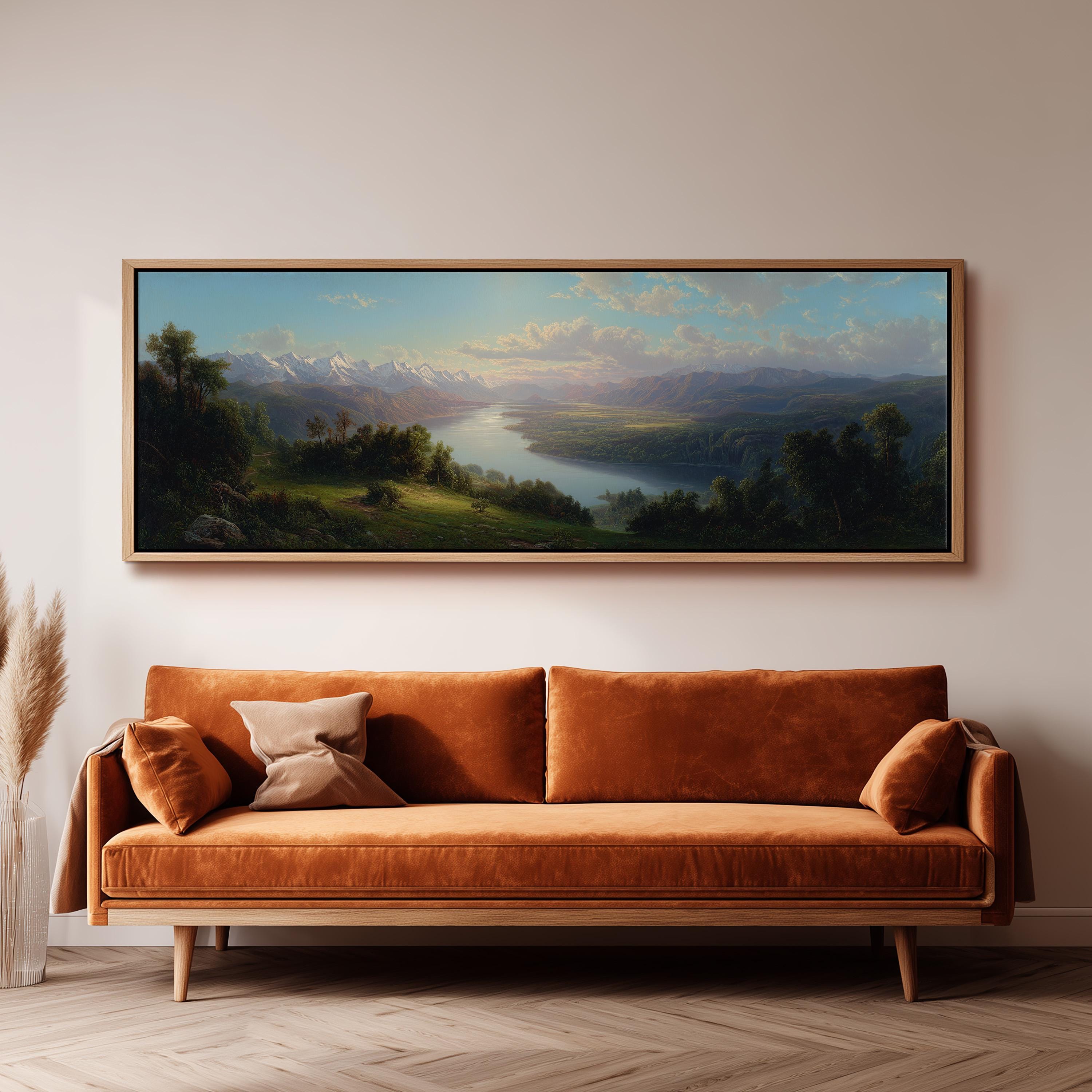 a large landscape painting hanging on a wall above a brown sofa with orange cushions.