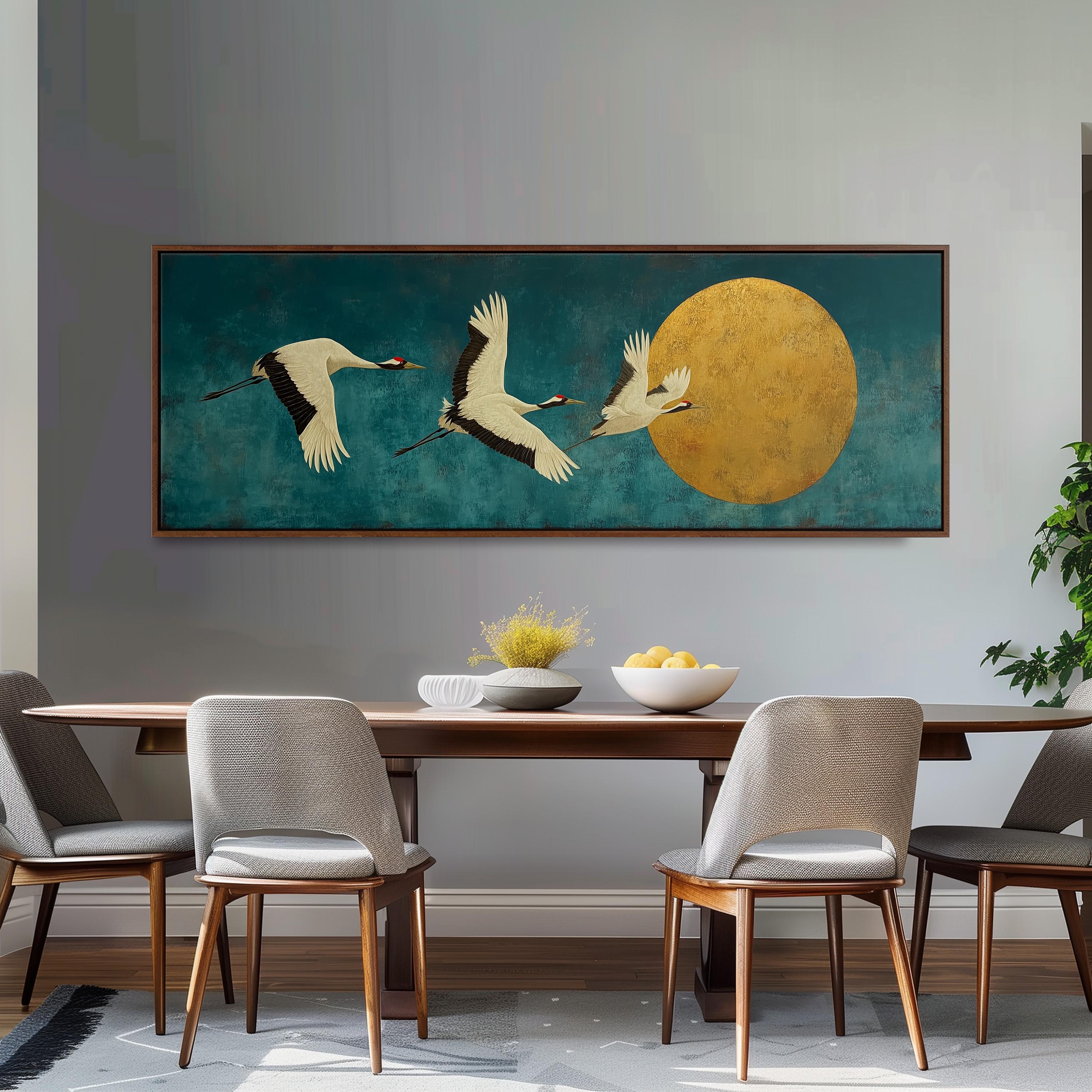 a large painting of three white birds in flight against a blue background, with a large yellow circle in the center. The painting is hanging on a wall above a wooden dining table with four chairs around it.