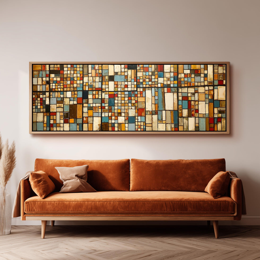 Earth tone mosaic grid in blue and ochre long horizontal canvas print above a sofa in a living room