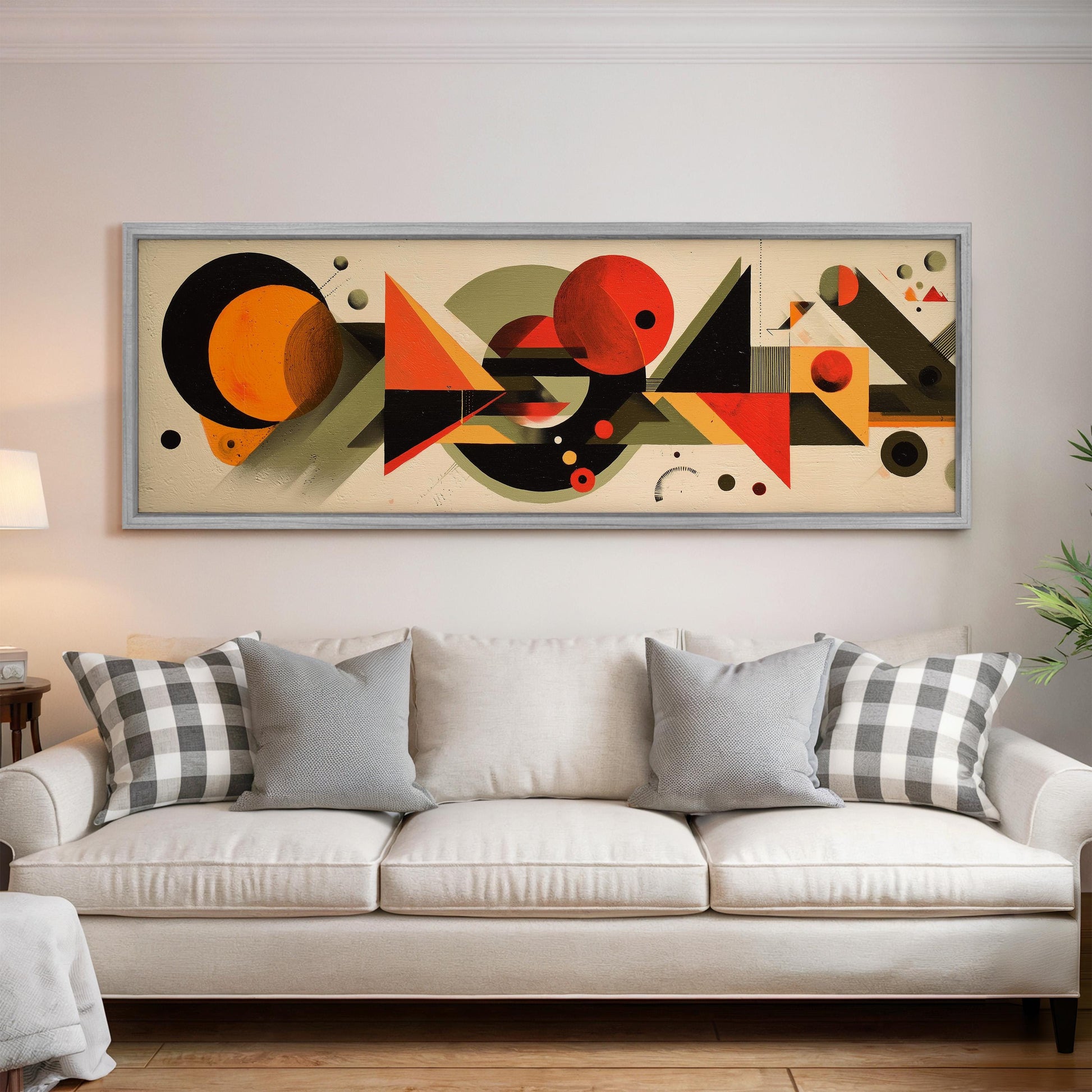 a large abstract painting hanging on a wall above a white couch with gray and white plaid throw pillows.