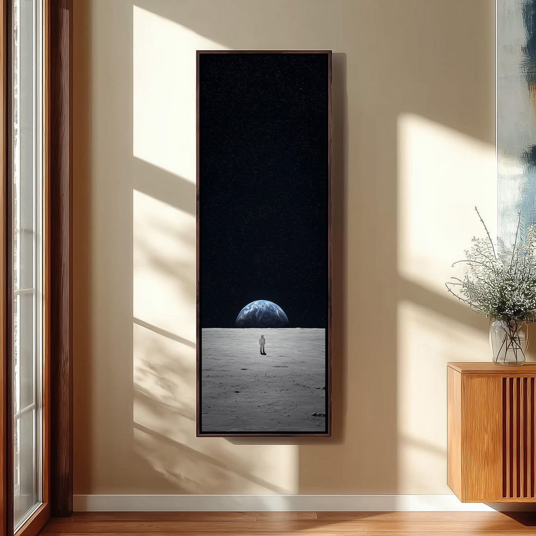 a person standing on a wooden staircase, with a large framed picture hanging on the wall above them.