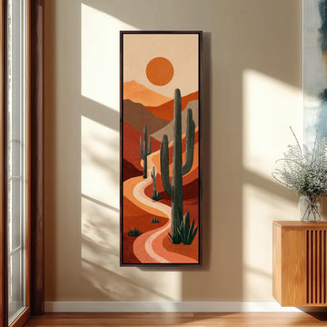 a large framed painting of a desert landscape with cacti and mountains in the background, hanging on a wall.