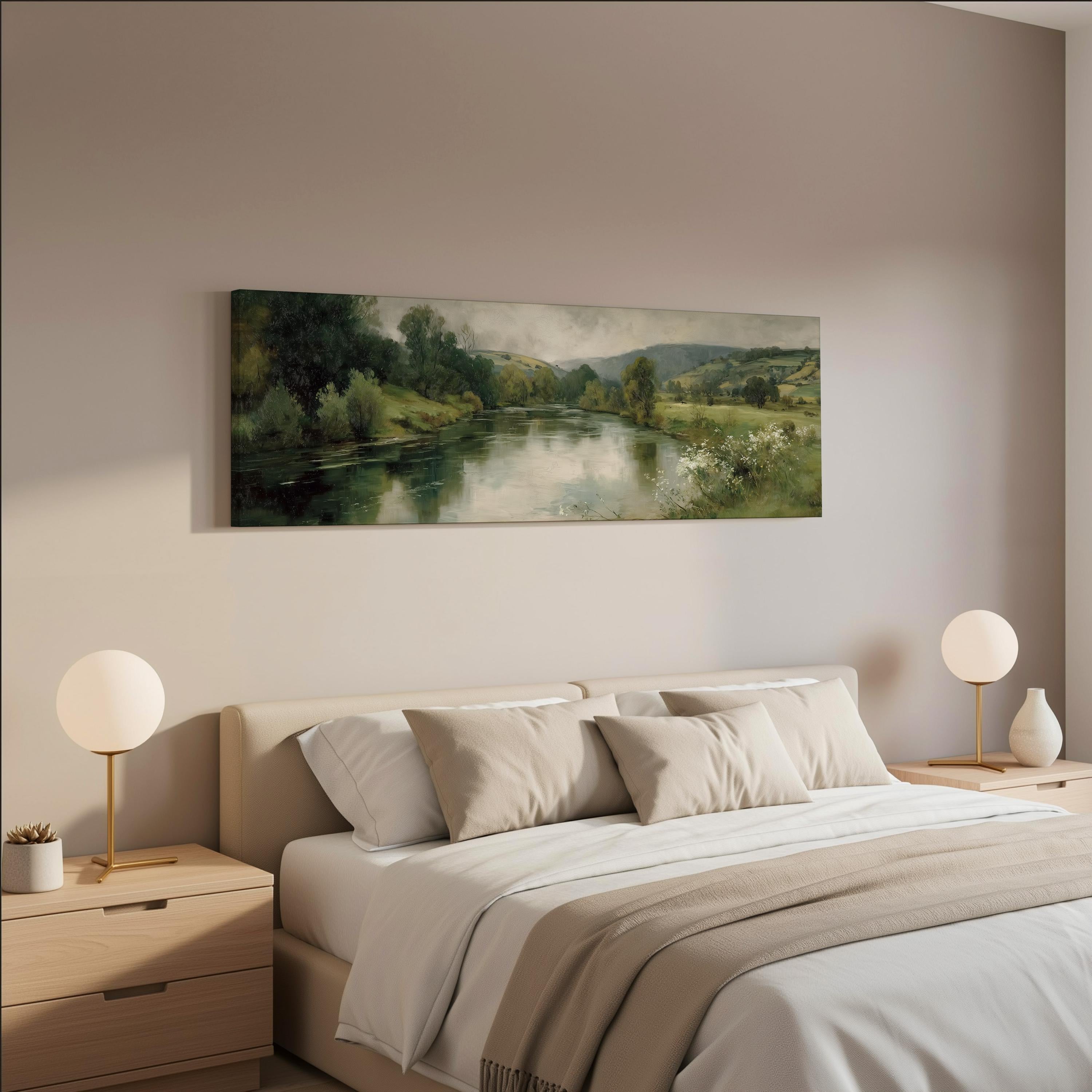 a serene bedroom scene with a large painting of a river and trees hanging on the wall above a bed with white bedding and beige pillows.