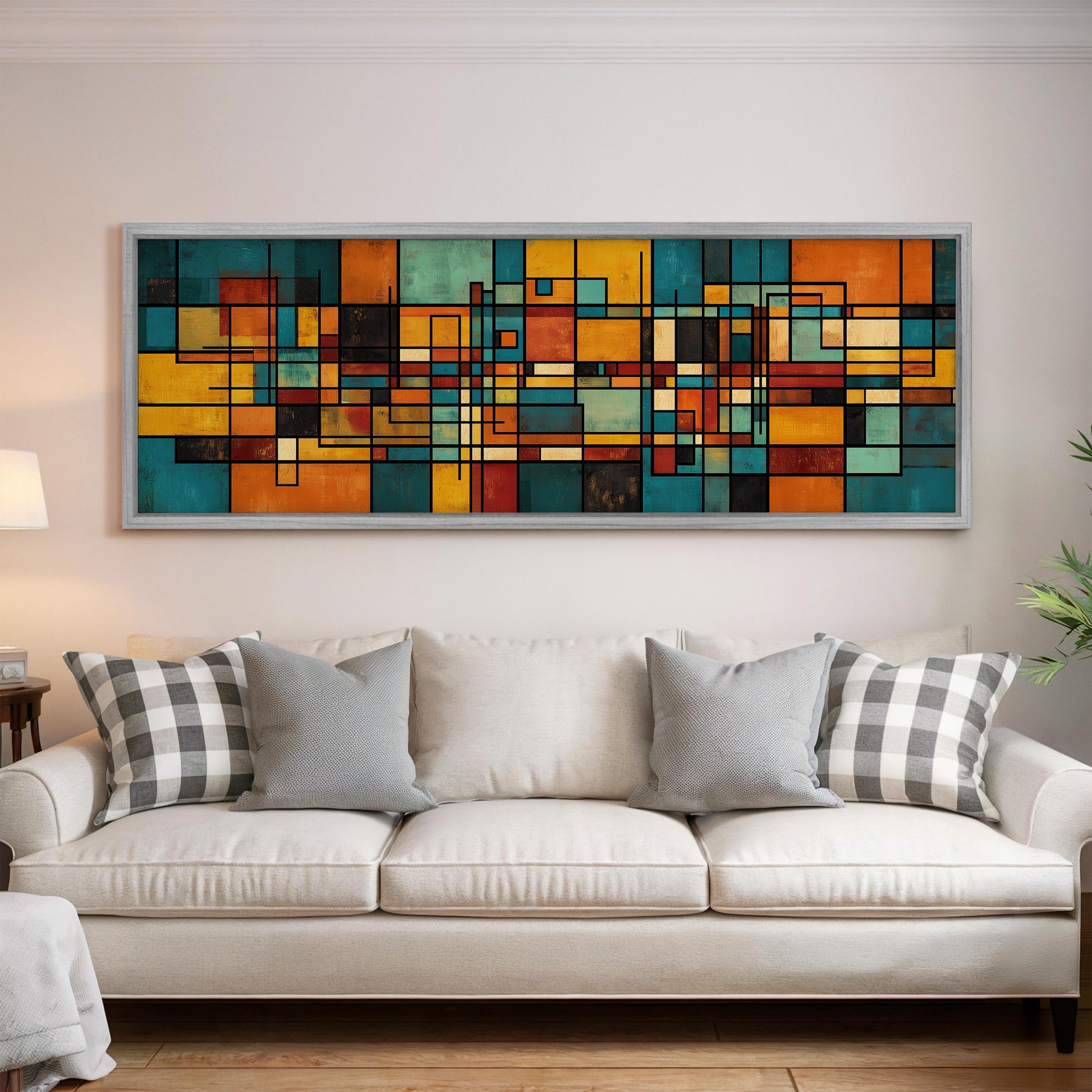 a large, colorful abstract painting hanging on a wall above a white couch with gray and white patterned pillows.