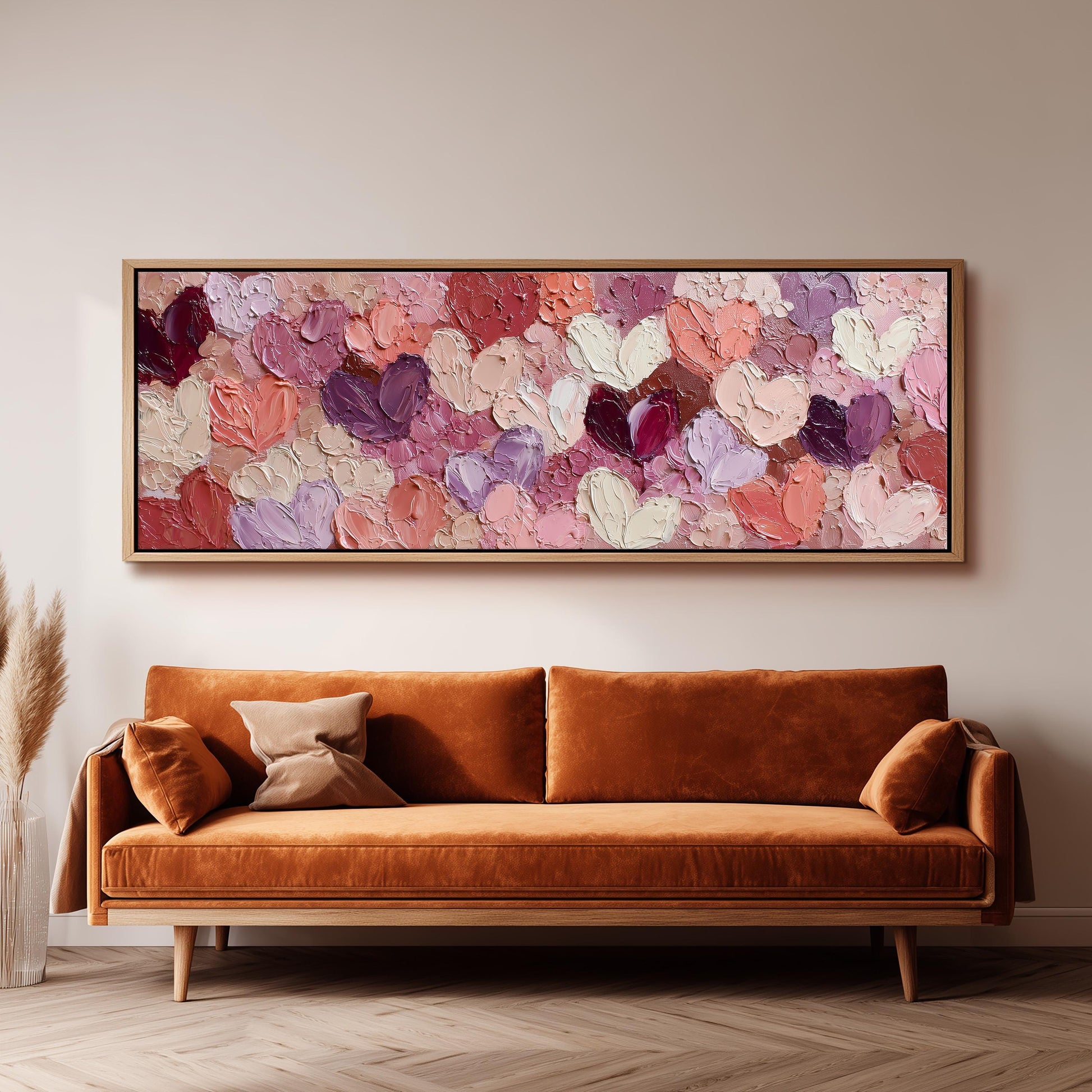 a large, rectangular painting hanging on a wall above a brown sofa with two pillows.