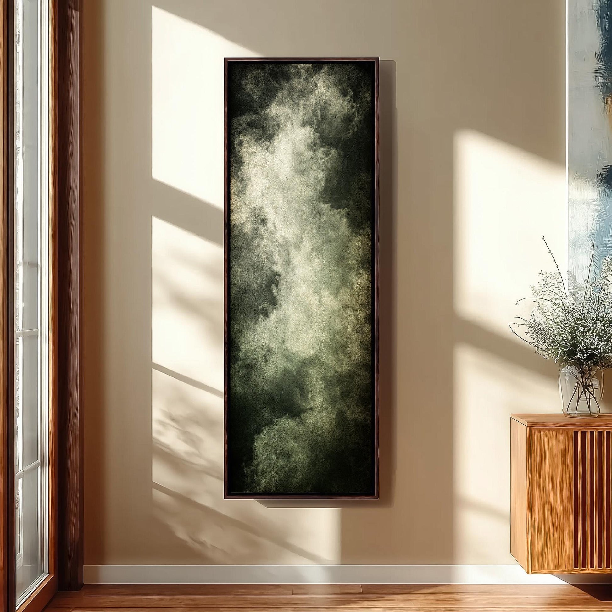 a large, dark-colored painting hanging on a wall, with a wooden cabinet and a vase of flowers placed next to it.