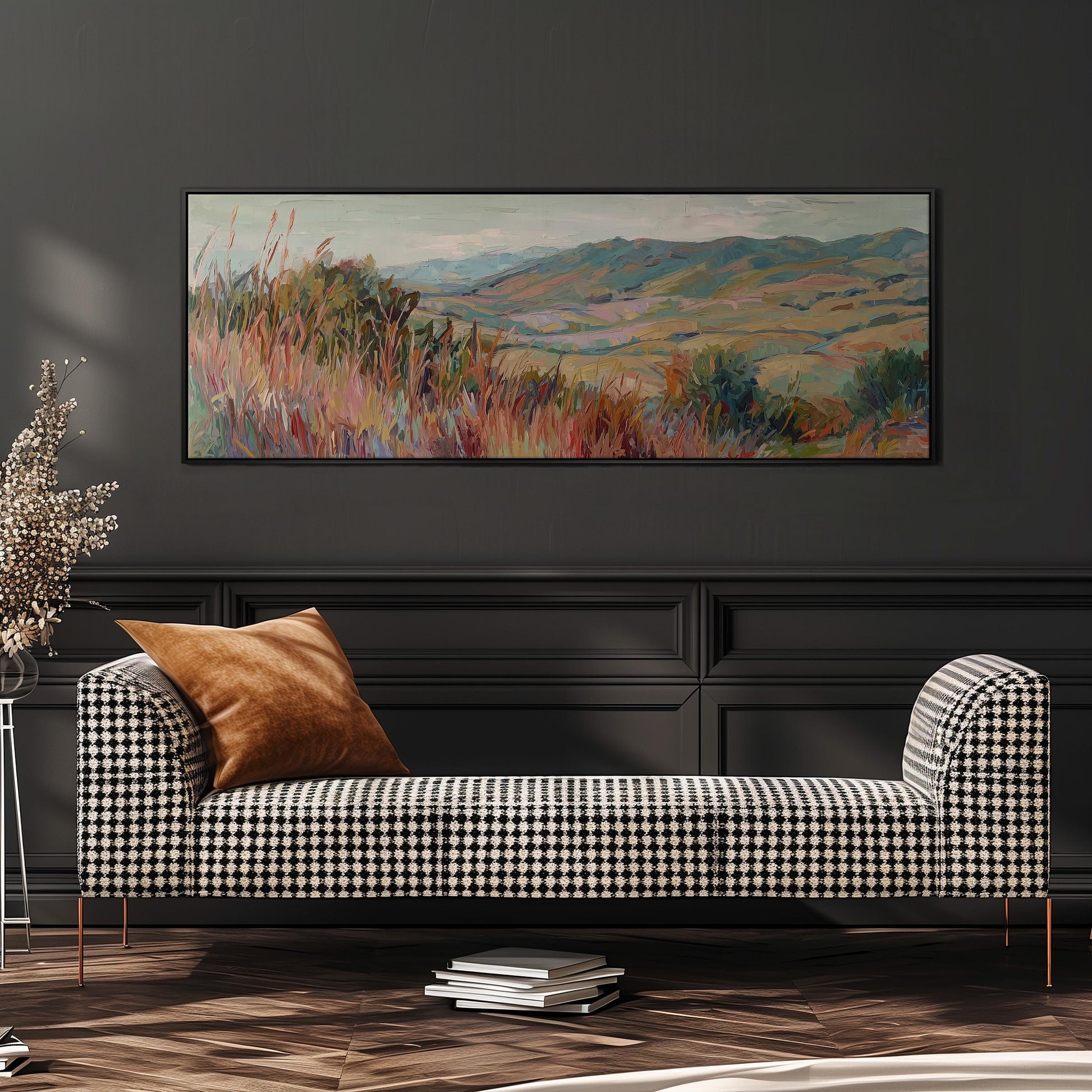 a large, colorful landscape painting hanging on a dark wall above a black and white checkered sofa with a brown throw pillow.