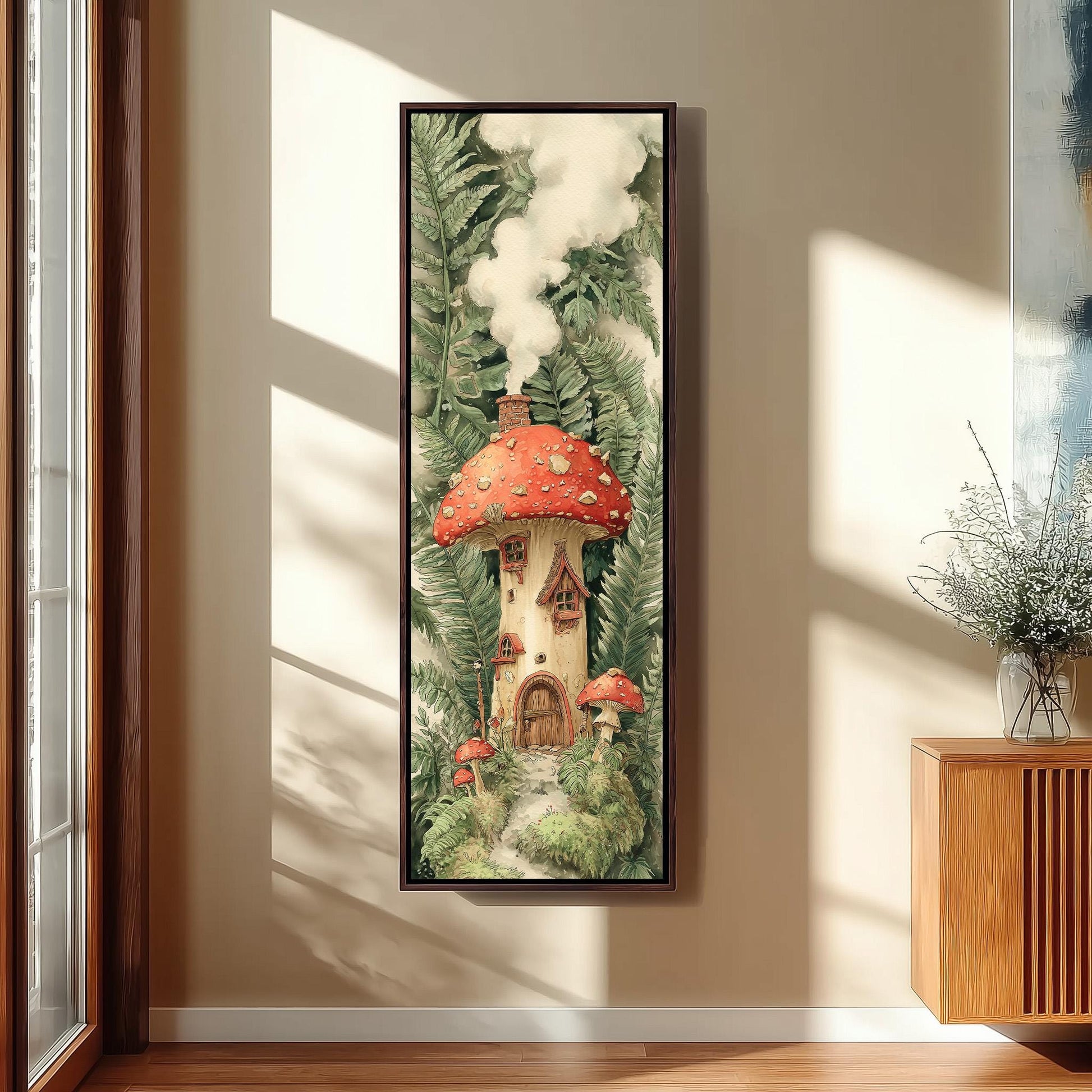 a framed painting of a mushroom house surrounded by lush greenery and mushrooms, hanging on a wall in a room with a window.