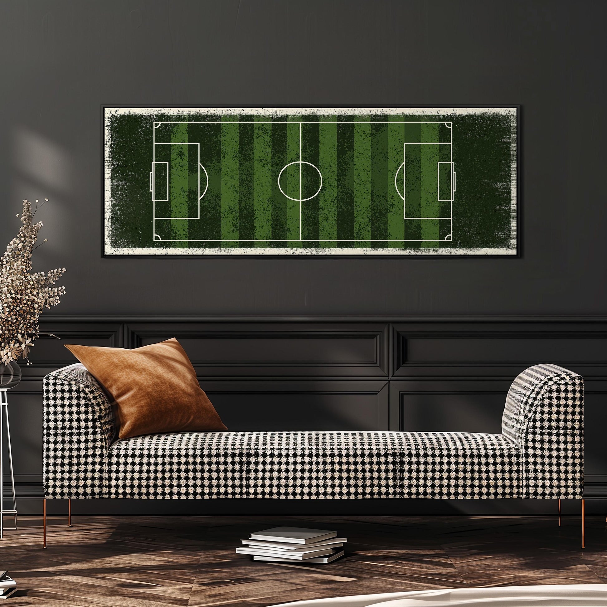 a modern living room with a black and white checkered sofa, a stack of books, and a large framed print of a soccer field on the wall.