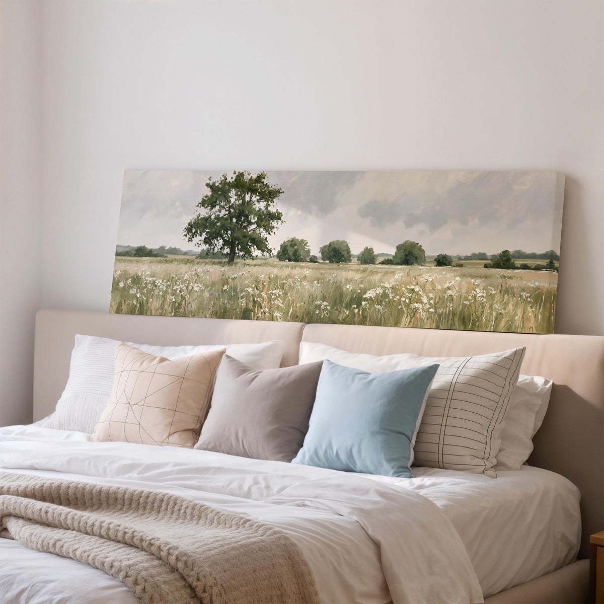 Lone oak tree in a daisy meadow wide panoramic canvas print above a bed in a bedroom