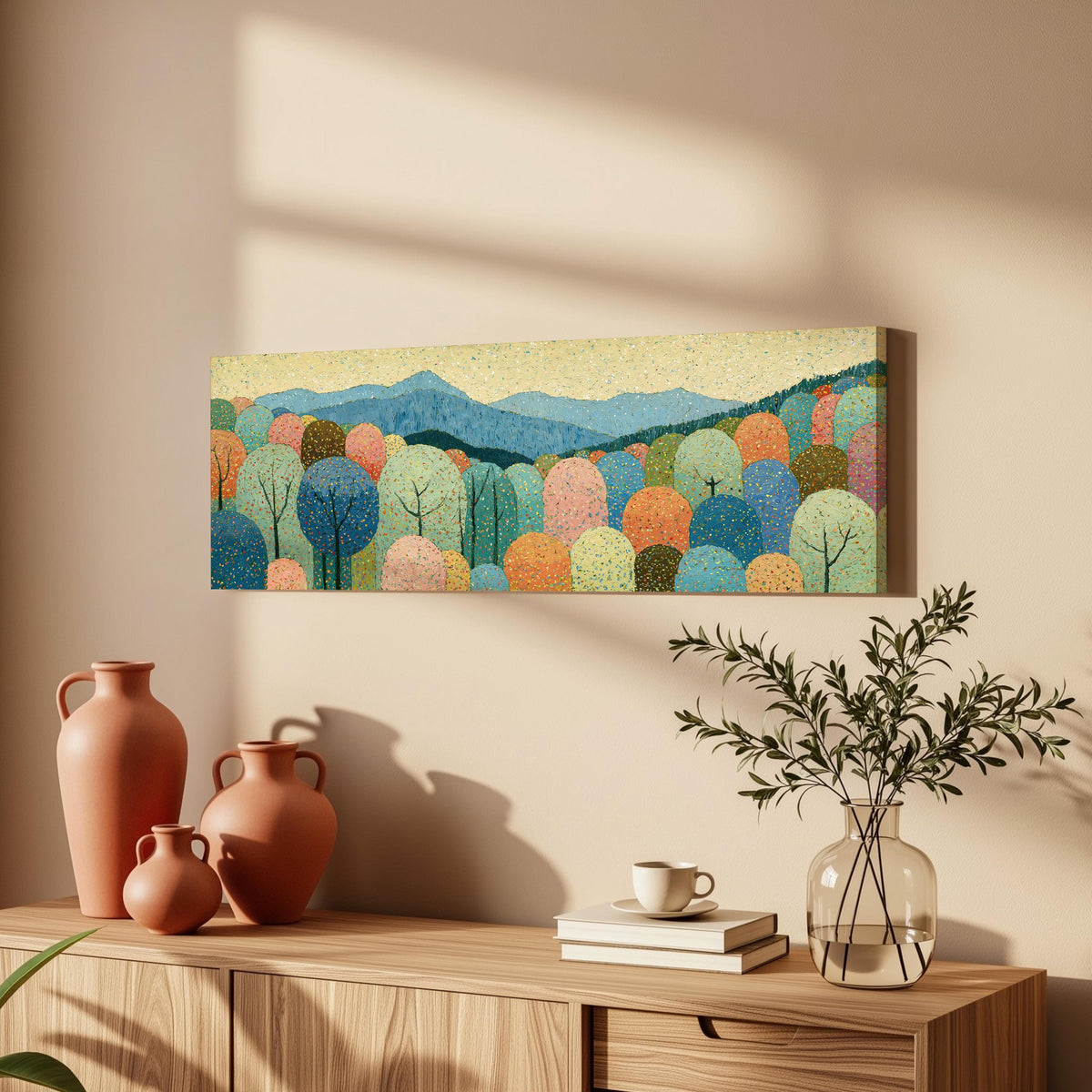 Pastel dotted forest below blue mountains long horizontal canvas print above a wooden sideboard