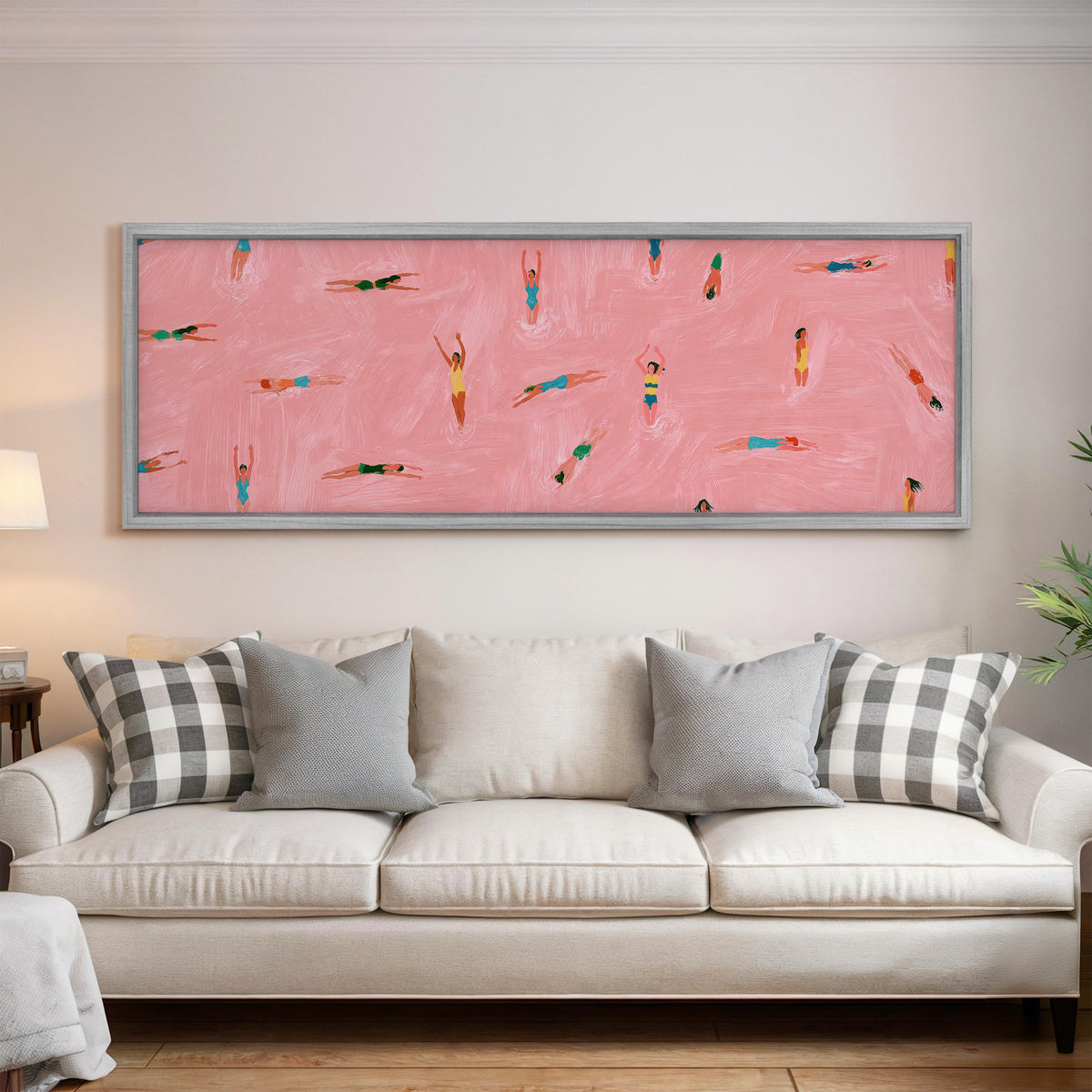 Tiny swimmers in a pink pool from above panoramic canvas print above a white sofa in a bright living room
