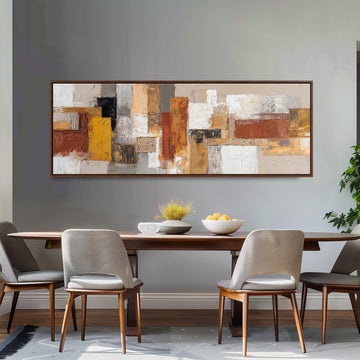 a dining room with a large abstract painting hanging on the wall above a wooden table with four chairs. The table is set with a bowl of fruit and a vase of flowers, creating a warm and inviting atmosphere.