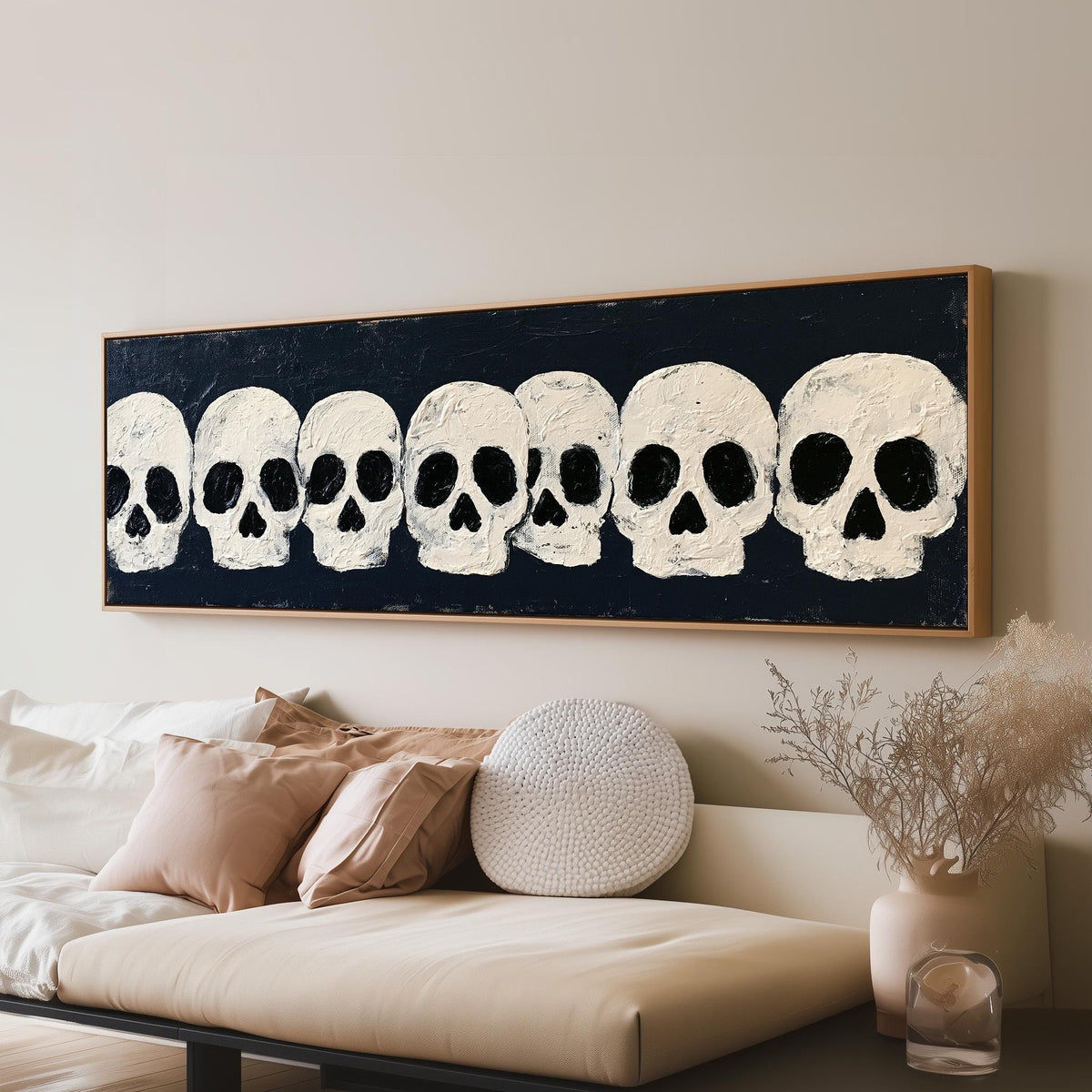 Row of white skulls on navy panoramic canvas print above a sofa in a living room