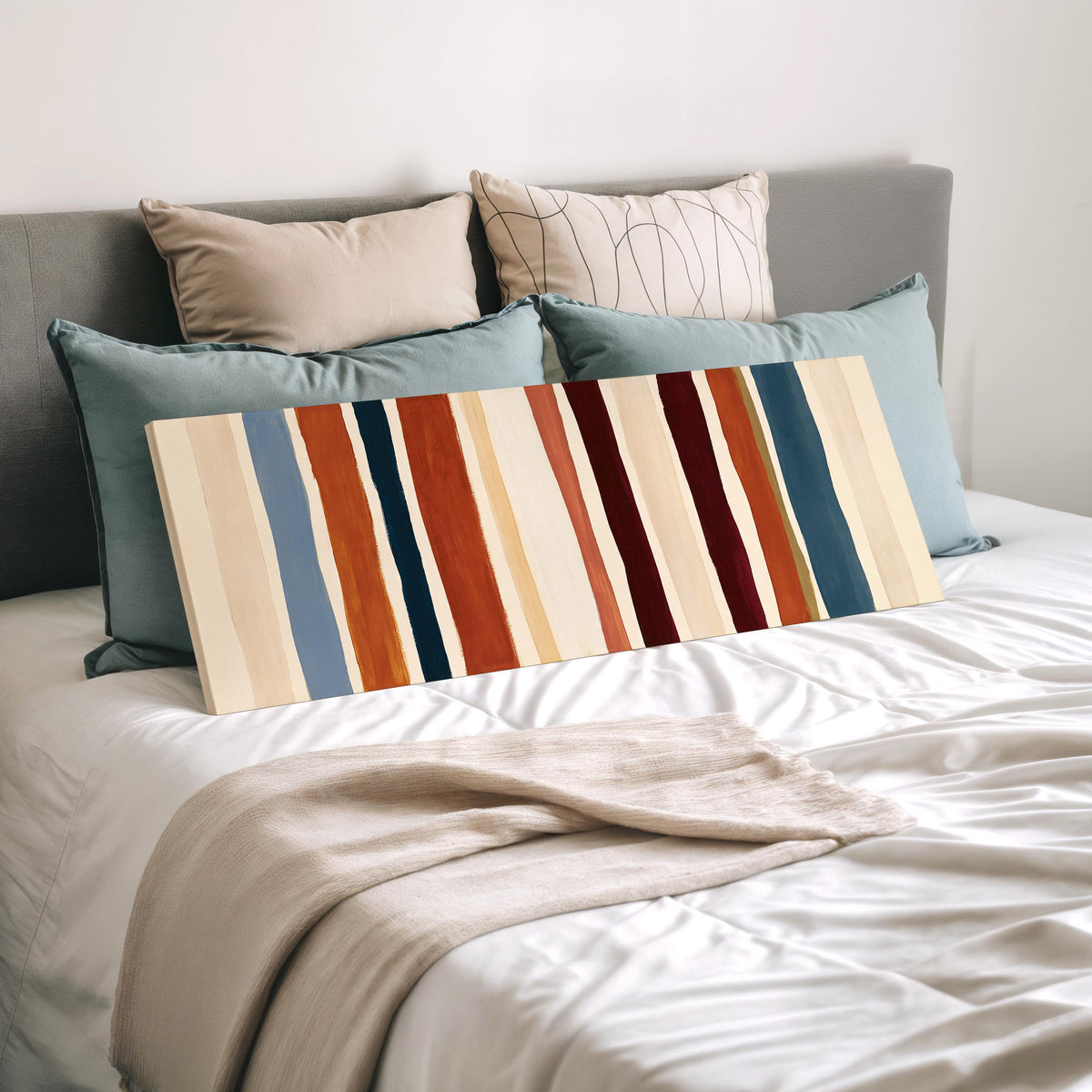 Rust, navy and maroon stripes wide panoramic canvas print laid on a bed to show its size