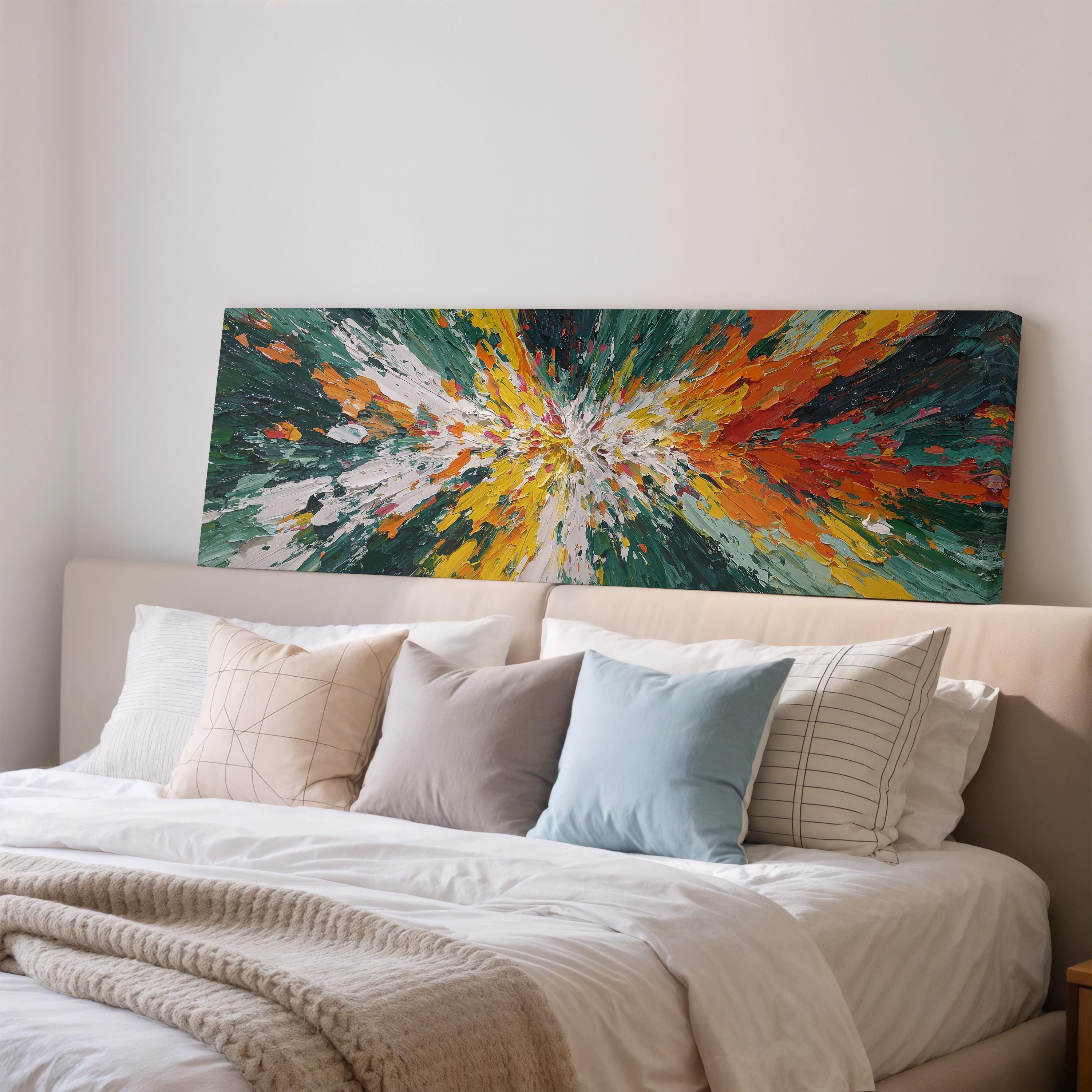 a large, colorful abstract painting displayed on a wall above a bed with white bedding and various pillows.