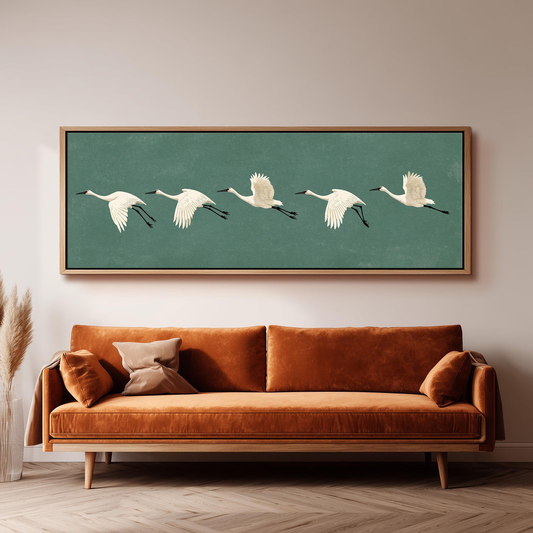 Five white cranes flying in formation long horizontal canvas print above a sofa in a living room